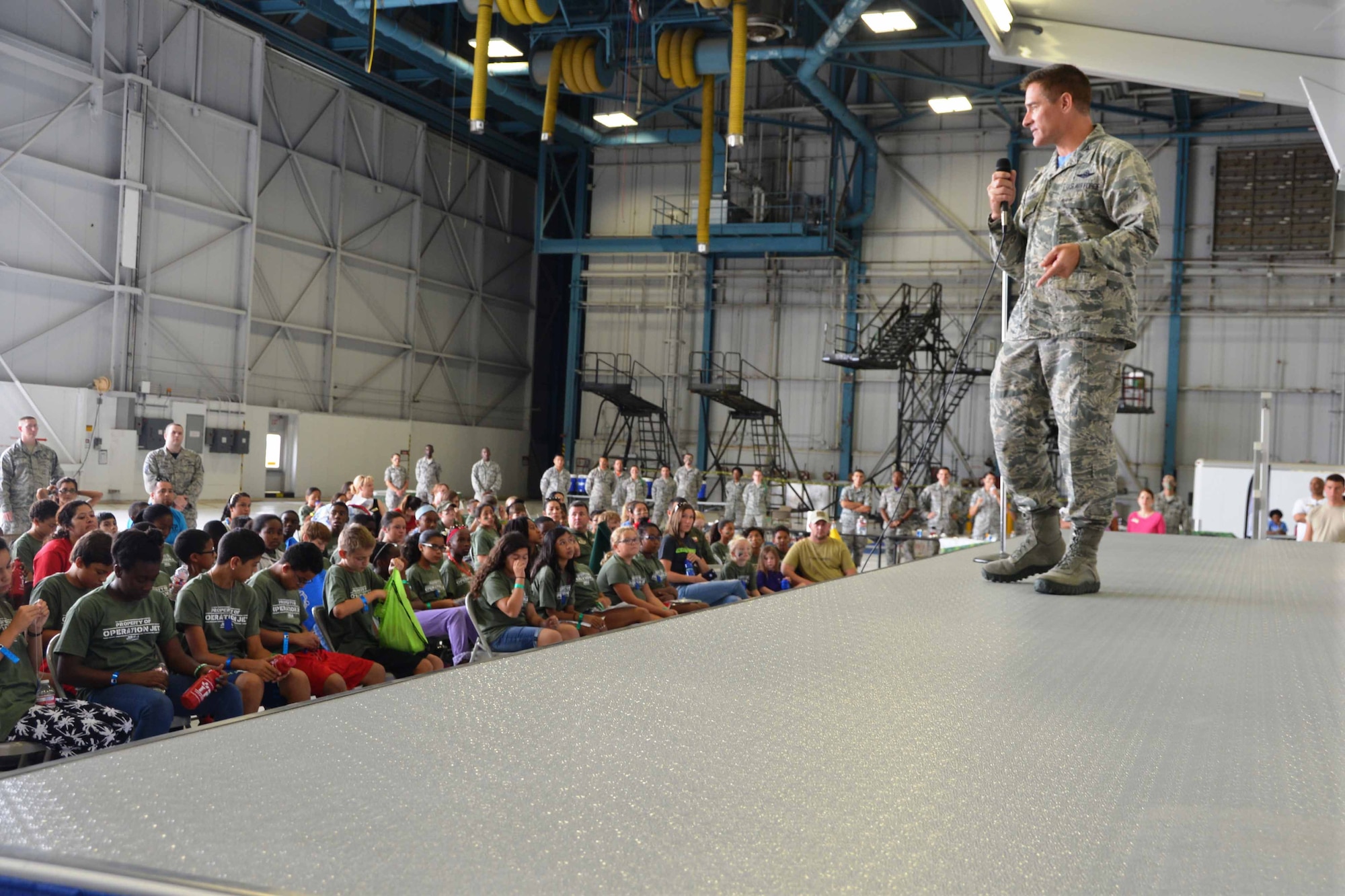 Col. William Whittenberger, 433rd Airlift Wing commander, Joint Base San Antonio-Lackland, Texas welcomes more than 200 children to Lackland’s Operation Junior Expeditionary Team event, July 31, 2015. Operation JET was hosted by the 802nd Military and Family Readiness Center and held in one of the 433rd Airlift Wing’s aircraft hangers. (U.S. Air Force photo/Minnie Jones)