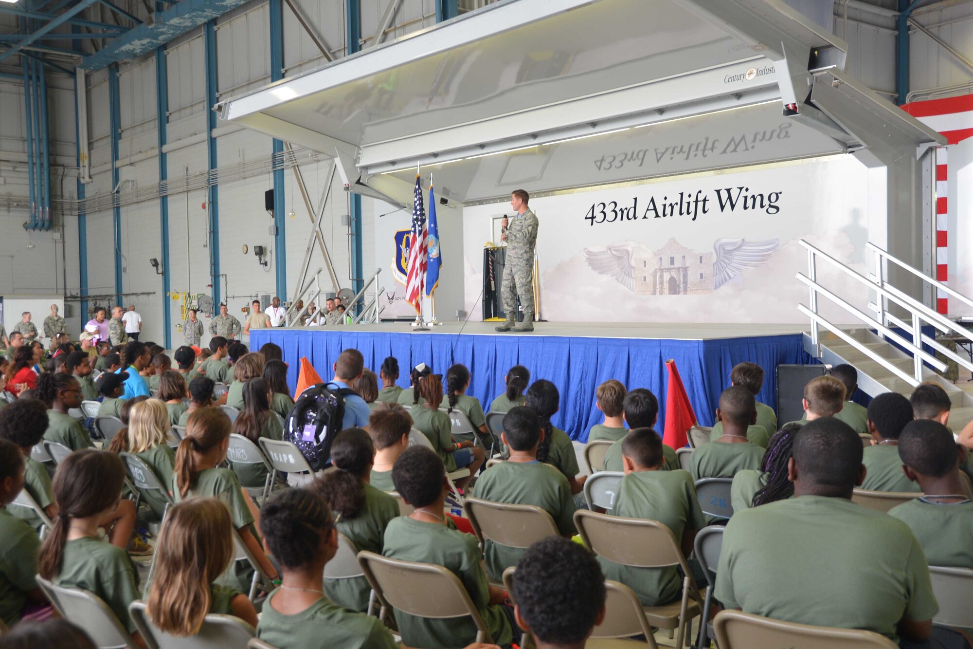 Col. William Whittenberger, 433rd Airlift Wing commander, Joint Base San Antonio-Lackland, Texas welcomes more than 200 children to Lackland’s Operation Junior Expeditionary Team event, July 31, 2015. The event was hosted by the 802nd Military and Family Readiness Center and held in one of the 433rd Airlift Wing’s aircraft hangers. (U.S. Air Force photo/Minnie Jones)