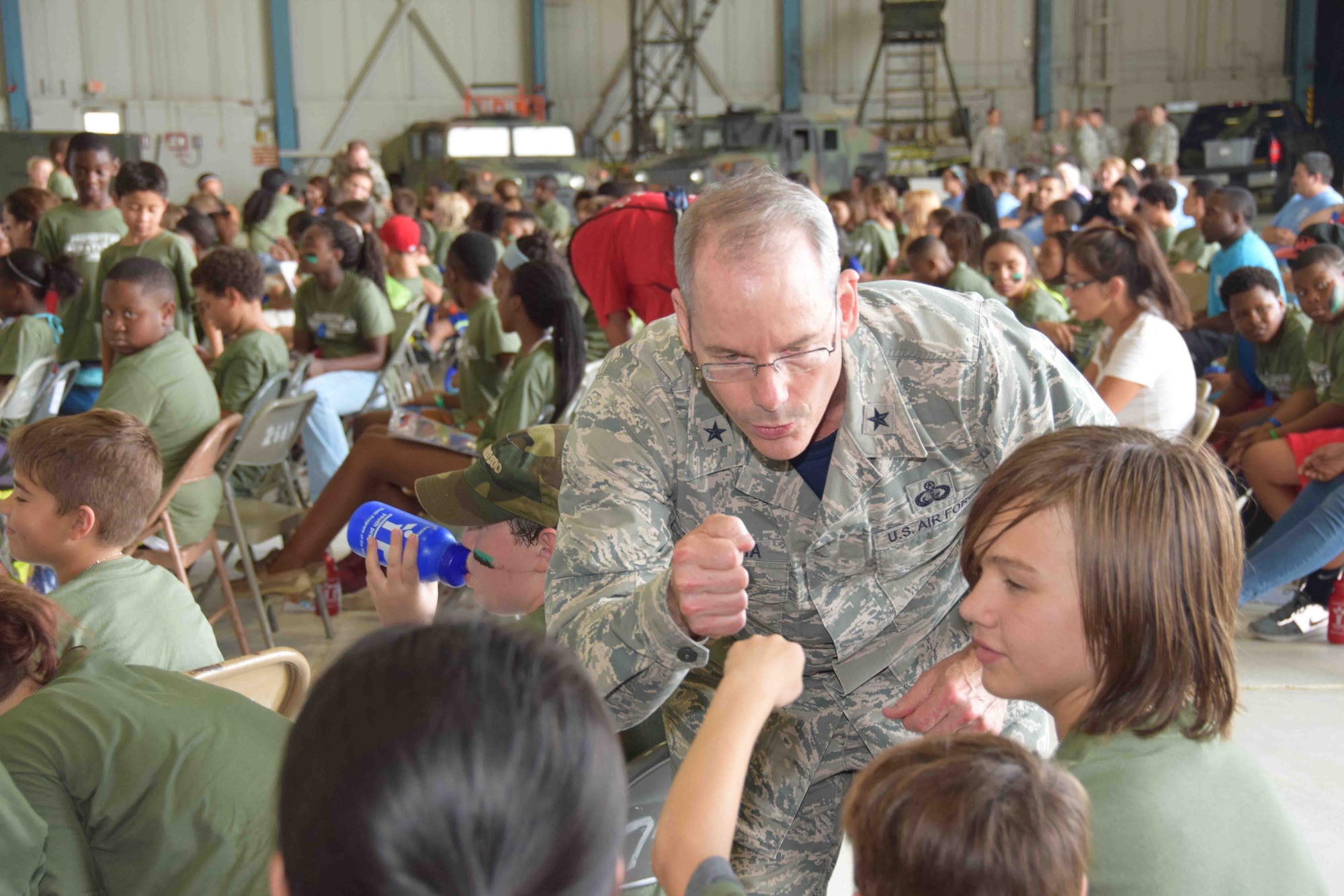 Brig. Gen. Robert La Brutta, 502nd Air Base Wing and Joint Base San Antonio commander, made the closing remarks at Operation JET for almost 200 children at Joint Base San Antonio-Lackland, Texas, July 31, 2015. The general then left the stage to give high fives and shake hands to thank the children for supporting their parents when they deploy. (U.S. Air Force photo/Tech. Sgt. Carlos J. Trevino)