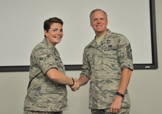 Airman 1st Class Kathy Butler, 359th Training Squadron student, shakes Chief Master Sgt. of the Air Force James Cody’s hand at Eglin Air Force Base, Fla., July 30, 2015. Cody awarded Butler her “Red Rope” which is a symbol or rank for Airmen leaders while they are in their technical schools. (U.S. Air Force Photo/Senior Airman Andrea Posey)