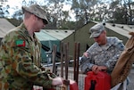 Australian Pvt. Ben Pawelski, a storeman assigned to the 9th Combat Services
Support Battalion, Australian Defence Force, stationed at Warradale Barracks,
Adalaide, South Australia and U.S. Army Staff Sgt. Bryan Strother, a radio
operator with the California Army National Guard's 40th Infantry Division,
work together unloading fire water buckets for issue to Soldiers participating in Talisman Sabre.