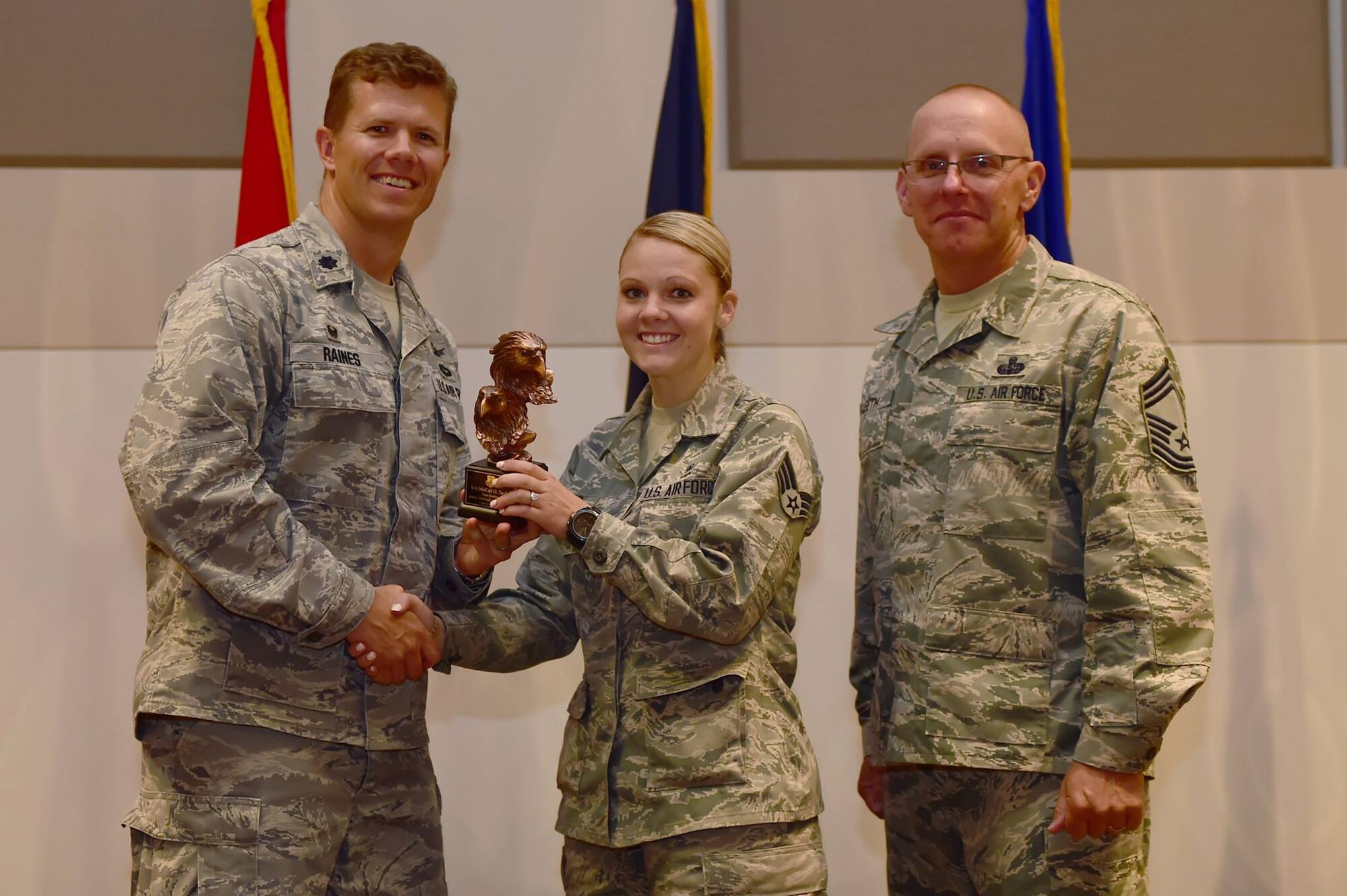 Lt. Col. Christopher Raines, Communications Operations Squadron West commander, and Chief Master Sgt. Richard Halseth, Aerospace Data Facility-Colorado senior enlisted leader, present the Junior Enlisted Award to Senior Airman McCall Taylor, Air Reserve Personnel Center total force assignment technician, during the Team Buckley second quarter awards ceremony July 30, 2015, on Buckley Air Force Base, Colo. (U.S. Air Force photo by Airman 1st Class Luke W. Nowakowski)