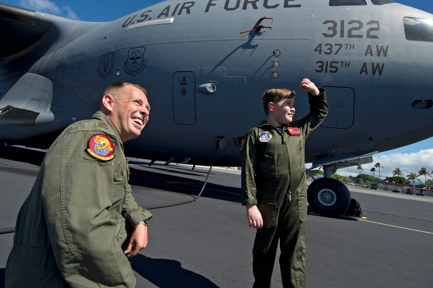 Nine-year-old Eddie Paul Bearb looks to the sky for high-flying aircraft with U.S. Air Force Maj. Jason Birdsall of the 535th Airlift Squadron after a static tour of a U.S. Air Force C-17 Globemaster III at Joint Base Pearl Harbor-Hickam, Hawaii, July 30, 2015. Eddie Paul had the opportunity to take break from the daily challenges he faces battling Acute Lymphoblastic Leukemia to spend the day being welcomed into the 535th Airlift Squadron as a Pilot For A Day. (U.S. Air Force photo by 2nd Lt. Kaitlin Daddona/Released)