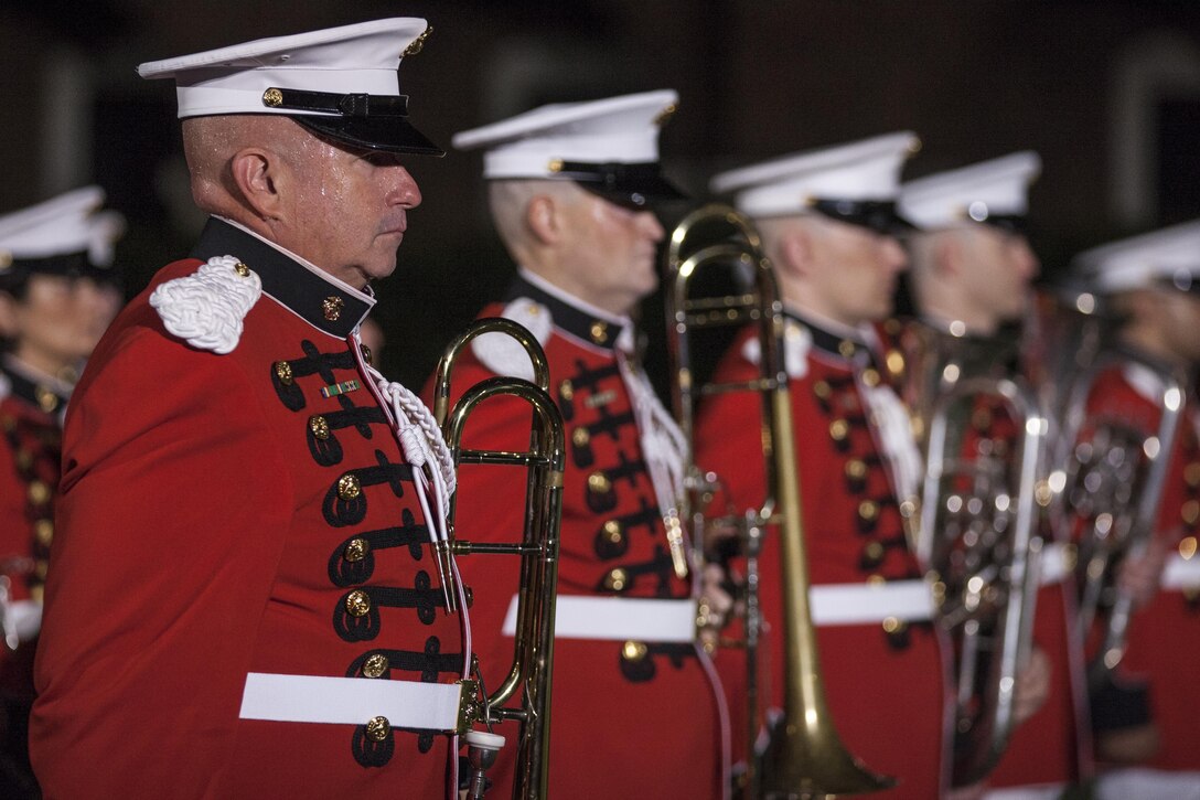 U.S. Marines with the Marine Band stand at attention during an evening parade at Marine Barracks Washington, D.C, July 31, 2015. U.S. Army Gen. Martin E. Dempsey, Chairman, Joint Chiefs of Staff, was the guest of honor for the parade at Marine Barracks Washington, D.C., and Gen. Joseph F. Dunford, 36th commandant of the Marine Corps, was the hosting official for that same parade.  The Evening Parade summer tradition began in 1934 and features the Silent Drill Platoon, the U.S. Marine Band, the U.S. Marine Drum and Bugle Corps and two marching companies. More than 3,500 guests attend the parade every week. (U.S. Marine Corps photo by Lance Cpl. Samantha K. Draughon/Released)
