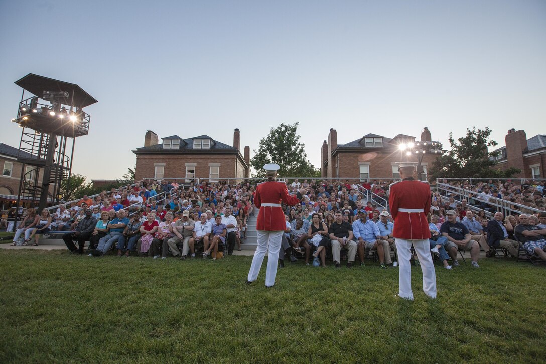 U.S. Marines with Marine Barracks Washington, D.C., speak to the crowd before an evening parade, July 31, 2015. U.S. Army Gen. Martin E. Dempsey, Chairman, Joint Chiefs of Staff, was the guest of honor for the parade at Marine Barracks Washington, D.C., and Gen. Joseph F. Dunford, 36th commandant of the Marine Corps, was the hosting official for that same parade.  The Evening Parade summer tradition began in 1934 and features the Silent Drill Platoon, the U.S. Marine Band, the U.S. Marine Drum and Bugle Corps and two marching companies. More than 3,500 guests attend the parade every week. (U.S. Marine Corps photo by Lance Cpl. Samantha K. Draughon/Released)
