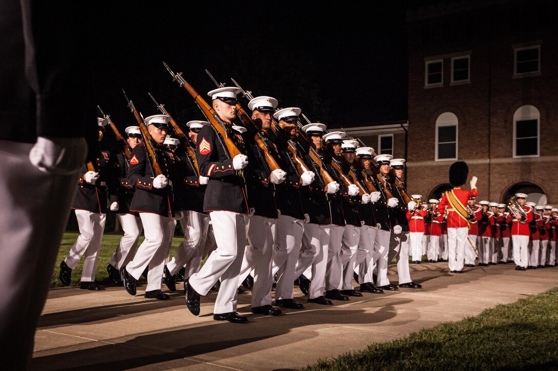U.S. Marines with Marine Barracks Washington, D.C., execute a Pass in Review during an evening parade, July 31, 2015. U.S. Army Gen. Martin E. Dempsey, chairman, Joint Chiefs of Staff, was the guest of honor for the parade at Marine Barracks Washington, D.C., and Gen. Joseph F. Dunford Jr., 36th commandant of the Marine Corps, was the hosting official for that same parade. The Evening Parade began in 1934 and features the Silent Drill Platoon, the U.S. Marine Band, the U.S. Marine Corps Drum and Bugle Corps, and two marching companies. More than 3500 guests attend the parade every week.(U.S. Marine Corps photo by Sgt. Melissa Marnell/Released)