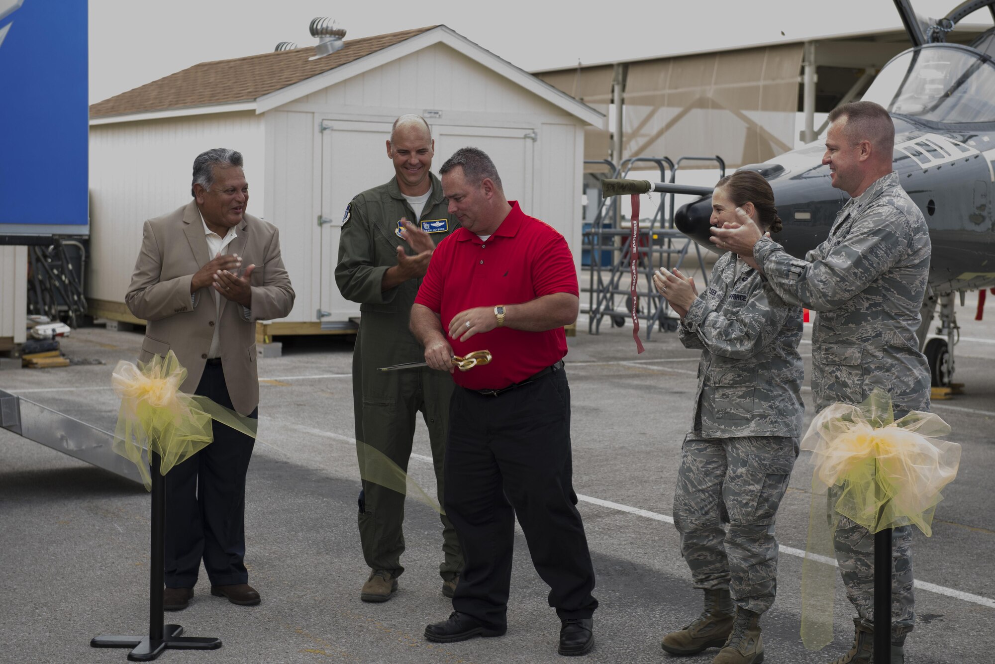 Robert Lewin, 575th Aircraft Maintenance Squadron director, cuts the ribbon at the unveiling ceremony of the first T-38 from the Pacer Classic III structural-modification program July 31, 2015, at Joint Base San Antonio-Randolph, Texas. Pacer Classic III is intended to ensure structural airworthiness of 150 T-38C aircraft and maintain T-38C fleet viability until 2029 and provides a bridge to the Air Force’s future trainer aircraft. (U.S. Air Force photo by Airman 1st Class Stormy Archer)