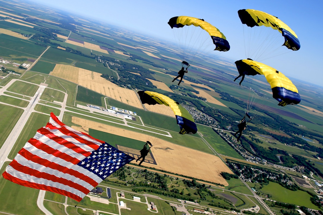 Members of the U.S. Navy Parachute Team, the Leap Frogs, perform a diamond formation while flying the American flag during a demonstration at the Fargo Air Show in Fargo, N.D., July 26, 2015. Based in San Diego, the Leap Frogs perform aerial parachute demonstrations around the nation to support naval special warfare and Navy recruiting. 