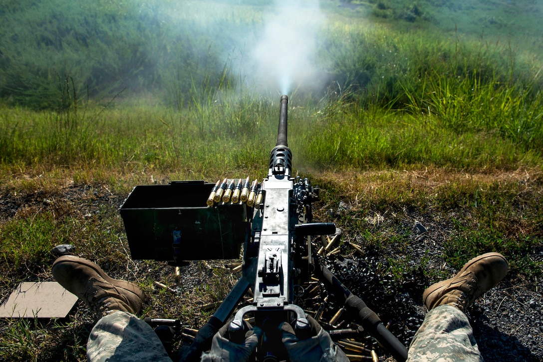 An Army reserve soldier fires a M2 Browning .50-caliber machine gun during Operation River Assault, a training exercise involving Army engineers and other support elements to create a modular bridge on the water across the Arkansas River on a gun range at Fort Chaffee, Ark., Aug. 2, 2015.
