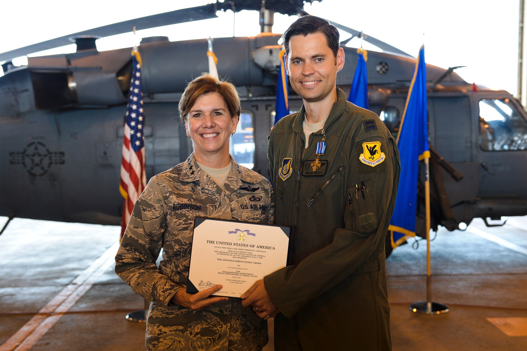 U.S. Air Force Gen. Lori Robinson, Pacific Air Forces commander, presents the Distinguished Flying Cross to U.S. Air Force Capt. Richard Scott, 33rd Rescue Squadron evaluator pilot, on Kadena Air Base, Japan, Aug. 3, 2015. Scott was awarded for his contribution in a harrowing rescue mission in Afghanistan May 26, 2011, when he provided a precision hoist to a squad of U.S. Army Pathfinders who were ambushed by multiple improvised explosive devices. (U.S. Air Force photo by Airman 1st Class John Linzmeier/Released) 