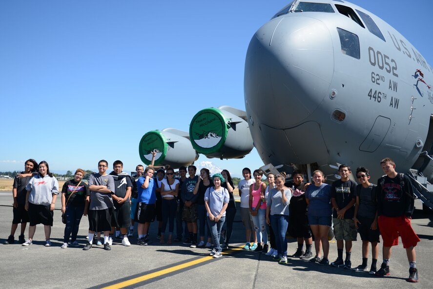 Members of the Nisqually Indian Tribe Youth and Community Center pose for a group photo in front of a McChord C-17 Globemaster III aircraft during their tour of McChord Field, Wash., July 30, 2015. The Nisqually Indian Tribe Youth and Community Center provides a culture program, daycare, an early childhood disability program, education, a library, and judicial services, among others. (U.S. Air Force photo/ Staff Sgt. Katie Jackson) 