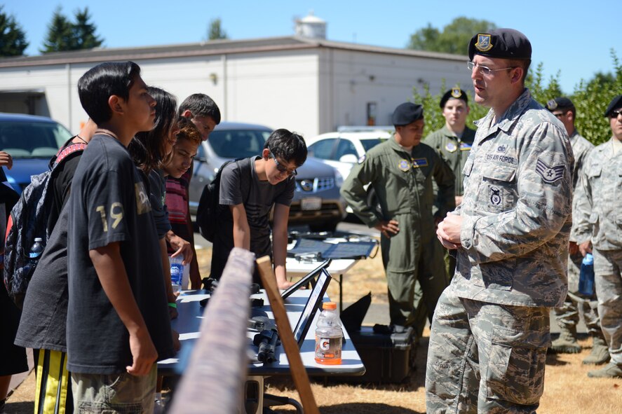 Staff Sgt. Kyle Mallon, 627th Security Forces Squadron security forces armorer, explains some of the weapons and equipment he and other security forces personnel are required to be sufficiently trained on to members of the Nisqually Indian Tribe during their tour of McChord Field, Wash., July 30, 2015. The goal of the tour was to create a partnership between organizations and to eliminate any perceived barriers about each other’s culture. (U.S. Air Force photo/ Staff Sgt. Katie Jackson) 