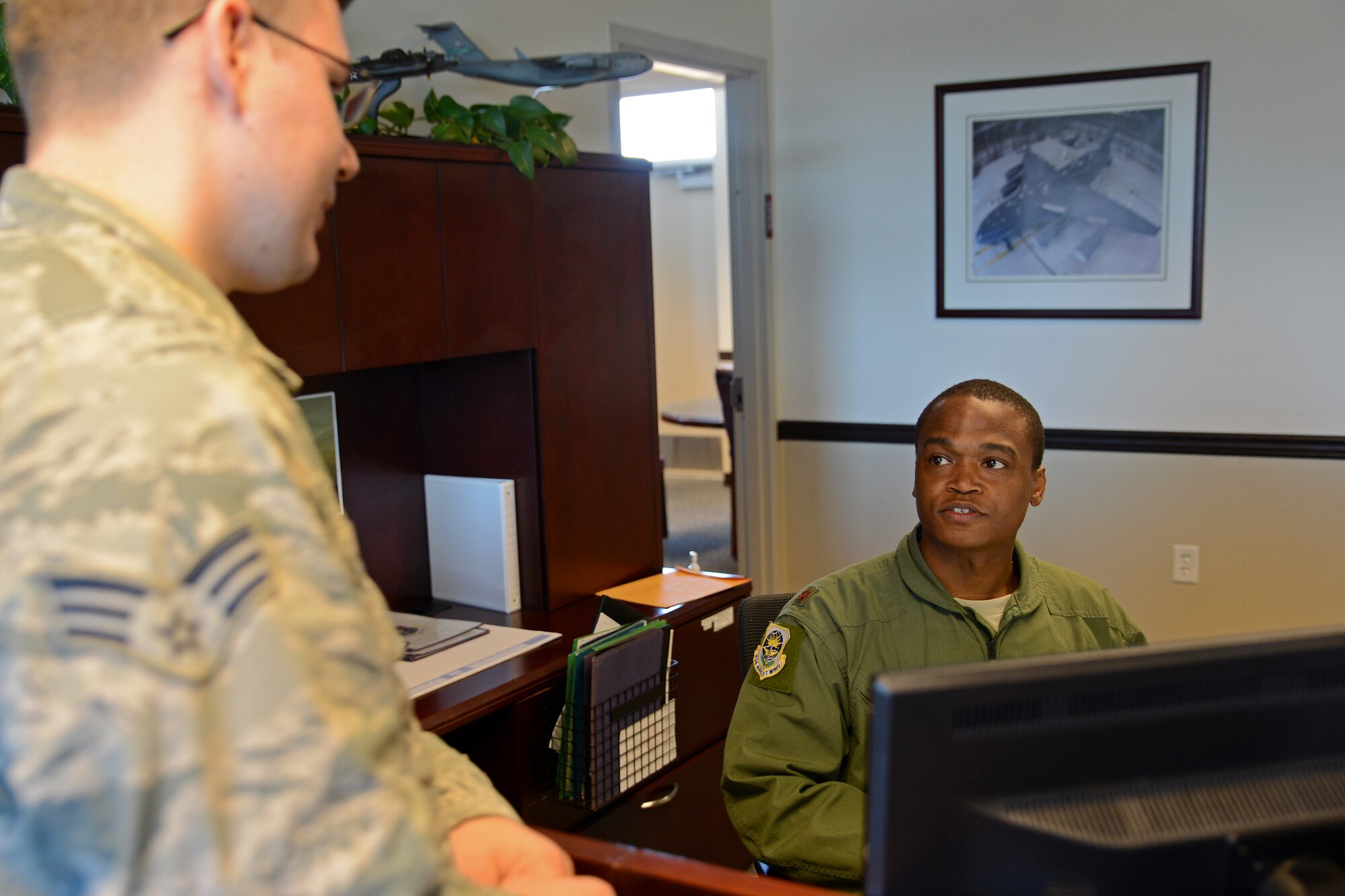 Maj. Robert Moore (right), 62nd Airlift Wing chief executive officer, talks to Senior Airman John Roy, 62nd AW executive administration support staff July 31, 2015, at Joint Base Lewis-McChord, Wash. Moore will be presented the General Benjamin O. Davis, Jr. Military Award during the Military Awards Luncheon on Aug. 19 in Las Vegas, Nev. (U.S. Air Force photo/Airman 1st Class Keoni Chavarria)