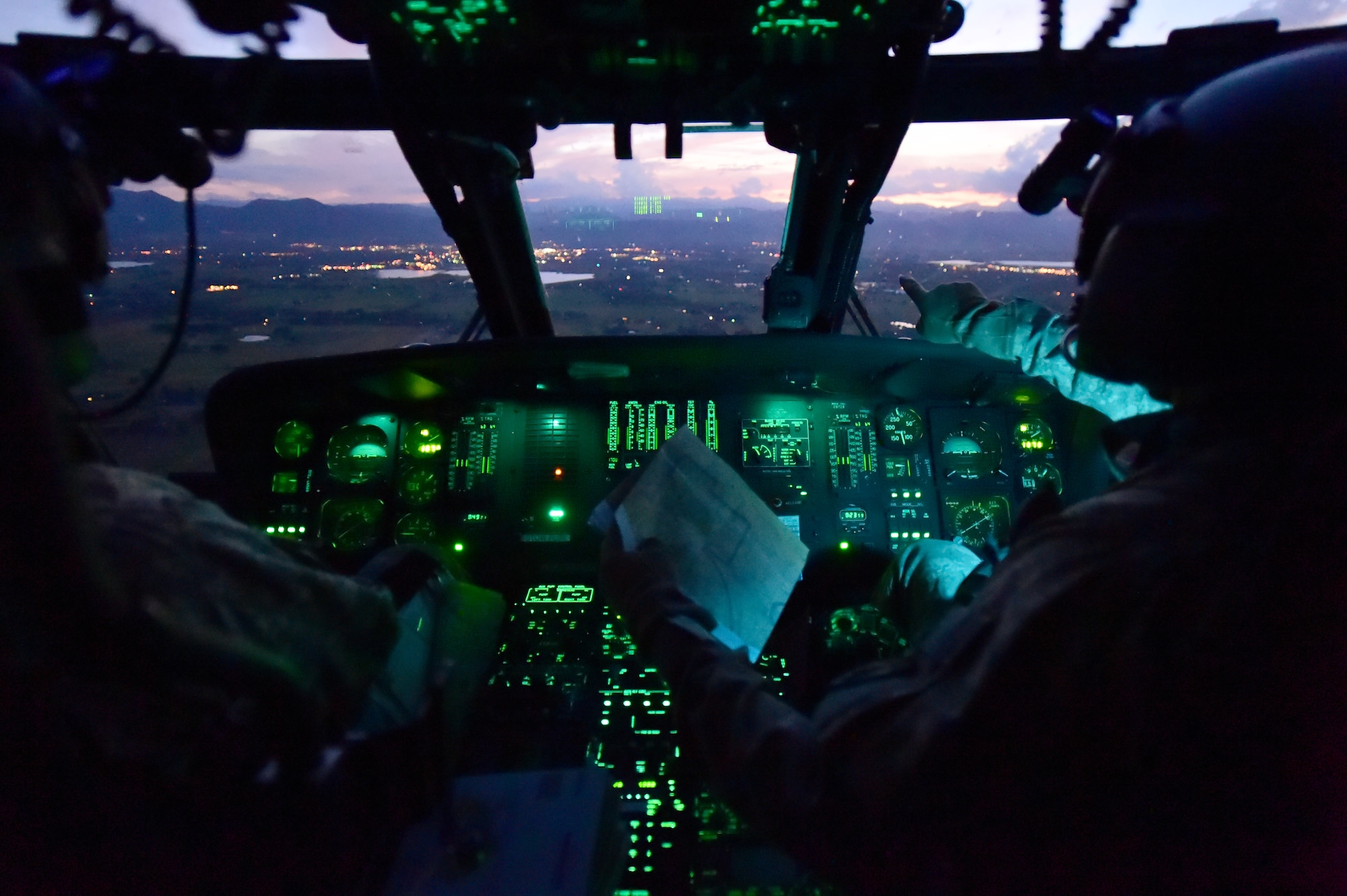Chief Warrant Officer Craig Wenkheimer, 2-135th Aviation Battalion UH-60 Black Hawk pilot, directs 1st Lt. David Otero, 2-135th Aviation Battalion UH-60 Black Hawk pilot, during an evening training flight July 29, 2015, on Buckley Air Force Base, Colo. The 2-135th Aviation Battalion is part of the Colorado Army National Guard and has a variety of capabilities that make it a valuable resource to both the state of Colorado and the U.S. Army. (U.S. Air Force photo by Airman 1st Class Luke W. Nowakowski/Released)
