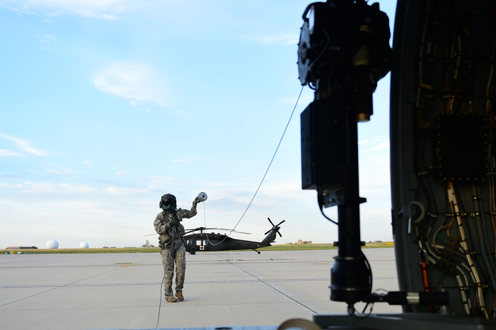 Sgt. Barbara Shirley, 2-135th Aviation Battalion crew chief, prepares the hoist before training July 29, 2015, on Buckley Air Force Base, Colo. The 2-135th Aviation Battalion is part of the Colorado Army National Guard and has a variety of capabilities that make it a valuable resource to both the state of Colorado and the U.S. Army. (U.S. Air Force photo by Airman 1st Class Luke W. Nowakowski/Released)