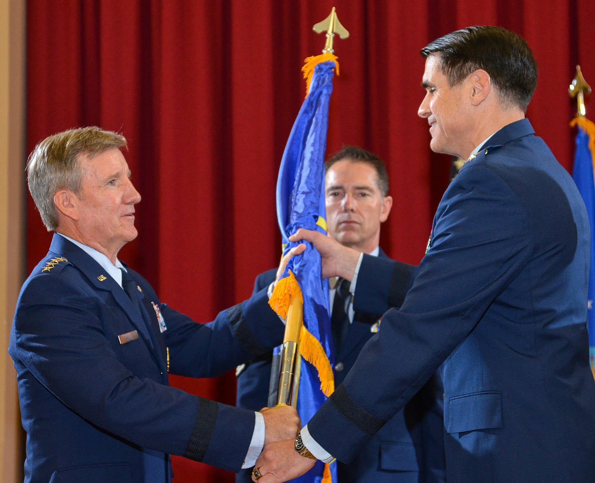 Gen. Herbert J. “Hawk” Carlisle, Commander, Air Combat Command, passes the 25th Air Force flag to Major Gen. Bradford J. “B.J.” Shwedo during the change of command ceremony on 3 Aug., 2015. (USAF photo by William B. Belcher)