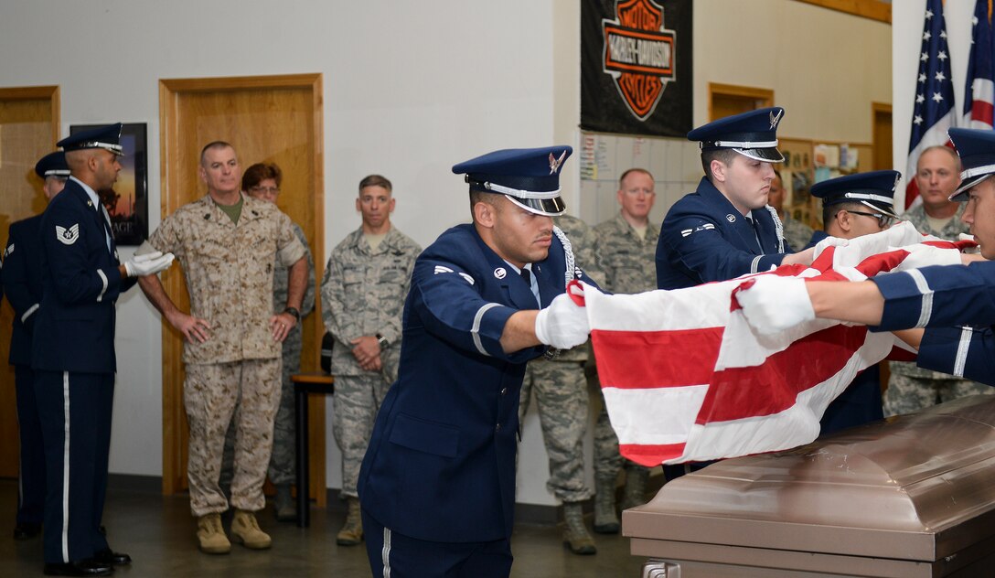 Airmen from the 22nd Air Refueling Wing Honor Guard demonstrate a six-man flag fold for U.S. Marine Corps Sgt. Maj. Bryan Battaglia, the senior enlisted advisor to the chairman of the joint chiefs of staff, July 30, 2015, at McConnell Air Force Base, Kan. Battaglia visited several different shops around the base, and the Honor Guard took the opportunity to demonstrate the military honors they render to deceased Service members around Kansas. (U.S. Air force photo by Senior Airman Colby L. Hardin)