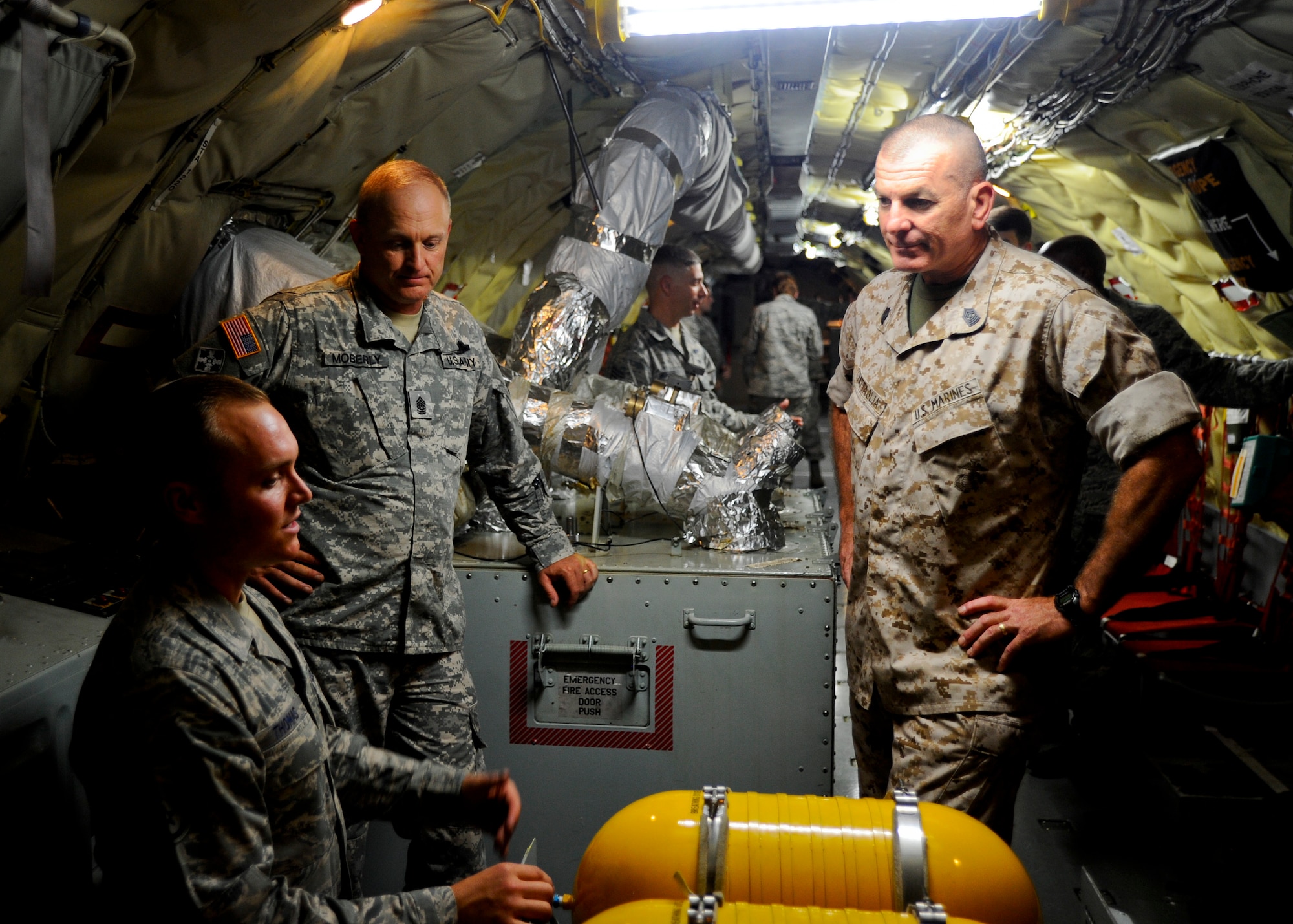 U.S. Air Force Staff Sgt. Devon Thomas, left, 22nd Aircraft Maintenance Squadron crew chief, discusses the responsibilities of a flying crew chief with U.S. Army Command Sgt. Maj. James Moberly, the senior enlisted Soldier in the Kansas Army National Guard, and U.S. Marine Corps Sgt. Maj. Bryan Battaglia, the senior enlisted advisor to the chairman of the joint chiefs of staff, July 30, 2015, at McConnell Air Force Base, Kan. The sergeants major visited with Airmen working the swing shift in the 22nd AMXS, where Thomas and several others gave an overview of how they maintain the nearly 60-year-old KC-135 Stratotanker. (U.S. Air Force photo by Senior Airman Victor J. Caputo)