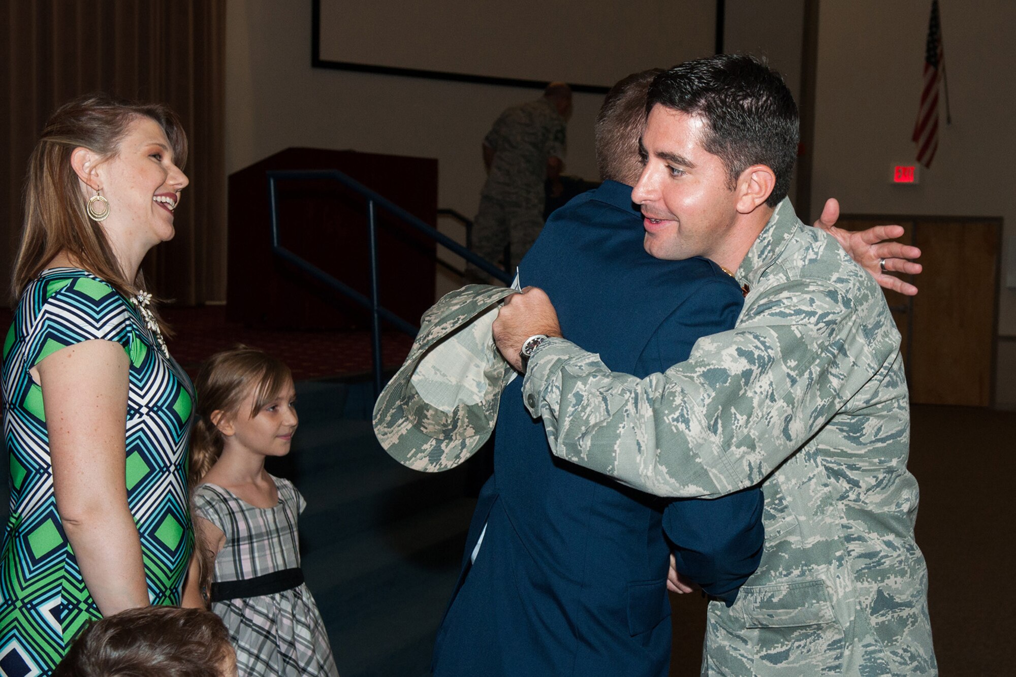 U.S. Air Force Maj. Peter Anderson, 8th Air Force Chief of Military Justice and Operations Law, congratulates Maj. George Cole III and his family on assuming command of the 307th Maintenance Squadron on Barksdale Air Force Base, La., Aug. 1, 2015. Cole is now the commander of the largest squadron in the 307th Bomb Wing. (U.S. Air Force photo by Master Sgt. Dachelle Melville/Released)
