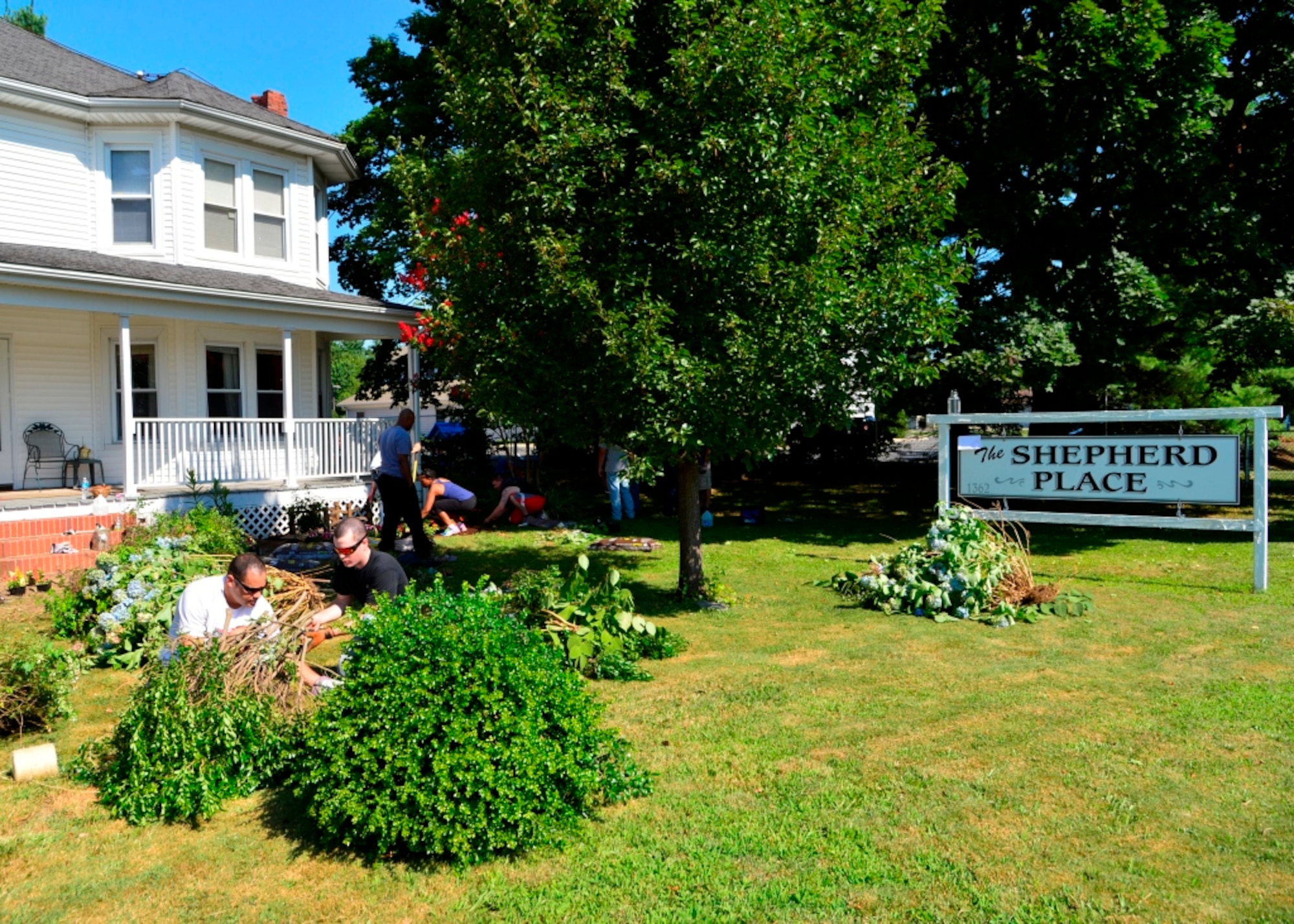 Students from the Staff Sgt. Julio Alonso Airman Leadership School class 15-F dig up old bushes and shrubs during a class volunteer project July 25, 2015, at the Shepherd Place in Dover, Del. The Shepherd Place is a non-profit organization that provides relief aid to homeless women and children. (U.S. Air Force photo/Airman 1st Class William Johnson)