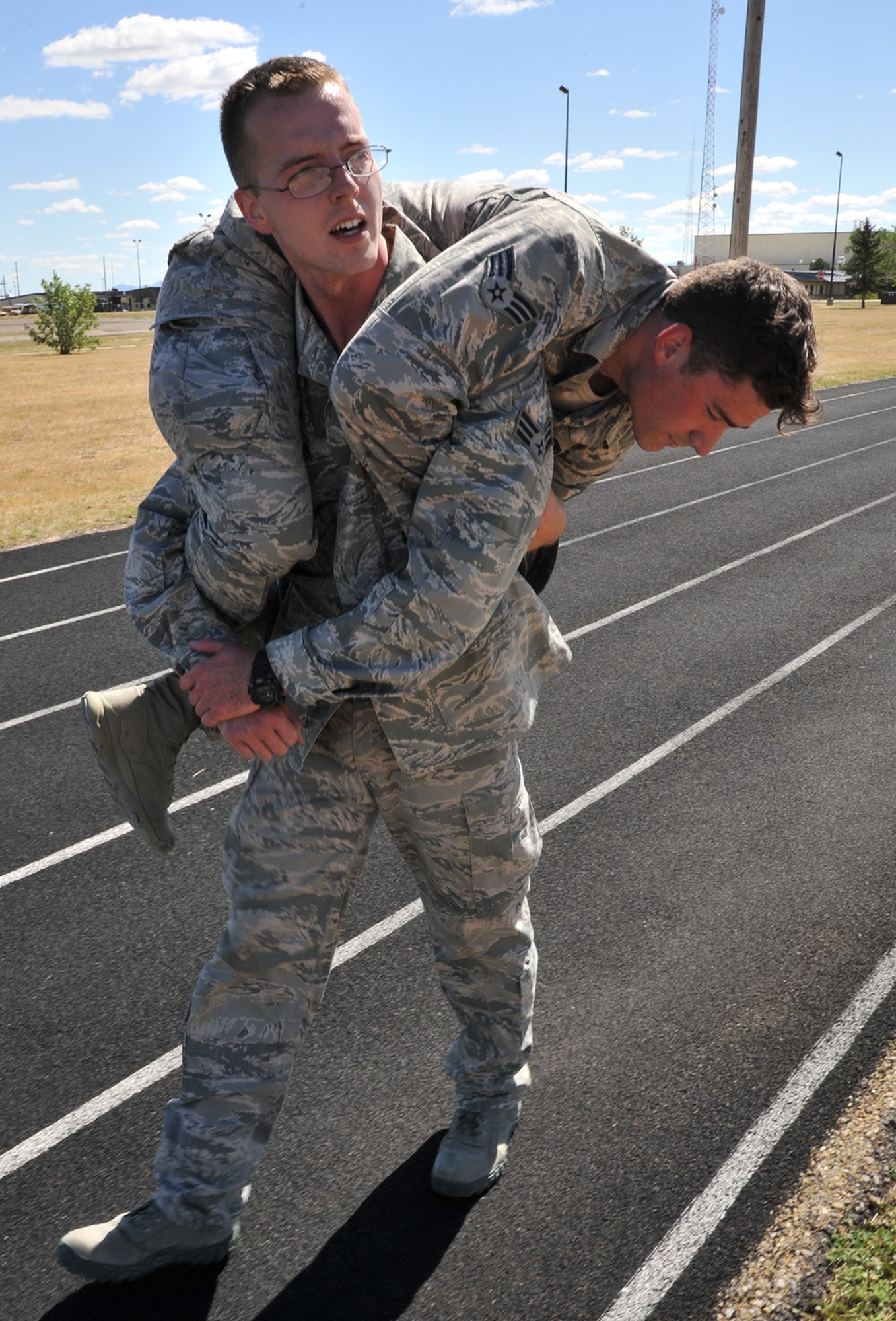 Senior Airman Zachary Conn, 341st Missile Security Forces Squadron, buddy carries Senior Airman Daniel Orcutt, 741st Missile Security Forces Squadron, July 29 during tryouts for Malmstrom’s Global Strike Challenge 2015 security forces team. A total of 16 candidates tried out for 12 positions on the team; the final team will be narrowed to six members after six weeks of training. (U.S. Air Force photo/John Turner)