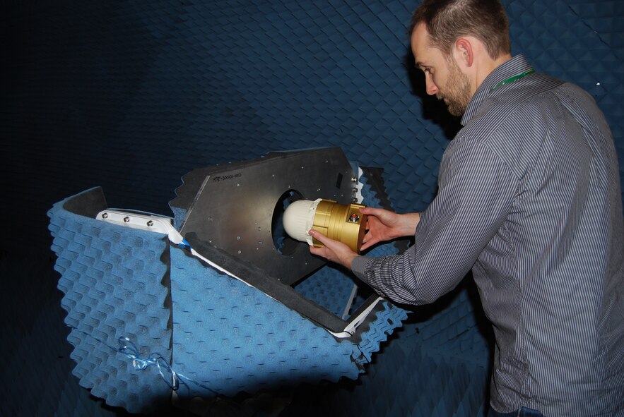 An L-3 Mustang engineer loads the MMW Smart Seeker into an antenna chamber fixture for radar system testing.