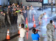 Airmen from the 341st Missile Wing soak the 341st Security Forces Group Commander, Col. Kenneth O'Neil, and the 341st MW Commander, Col. Tom Wilcox, at a combat dining out July 31, 2015, at Malmstrom Air Force Base, Mont. Airmen were encouraged to bring water-weapons to do battle at the mess with their fellow Airmen and the base leadership. (U.S. Air Force photo/Airman 1st Class Magen M. Reeves)