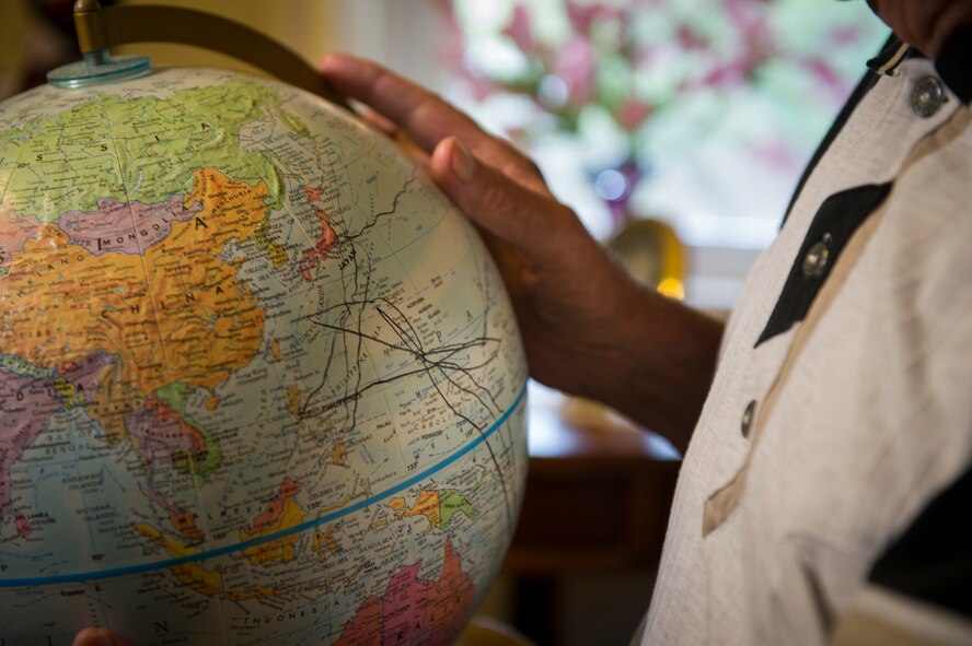 Lloyd Peterson, U.S. Navy World War II veteran, holds a globe at his home in Carpio, N.D., July 10, 2015. Peterson mapped the routes he took while aboard the USS Southampton from 1944 to 1946.  (U.S. Air Force photo/Senior Airman Apryl Hall)