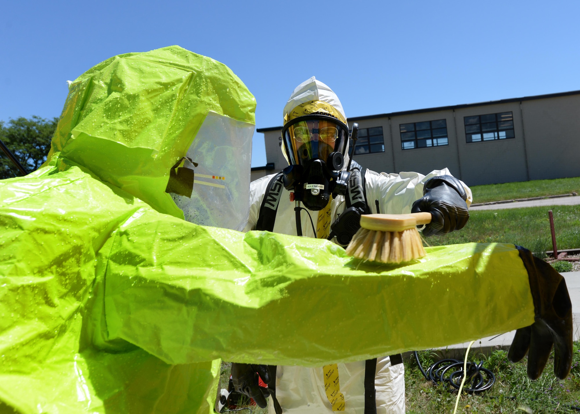 Airmen of the 28th Medical Operation Squadron bioenvironmental engineering flight process through a decontamination line during an integrated base emergency response capabilities training exercise at Camp Lancer at Ellsworth Air Force Base, S.D., July 16, 2015.The decontamination process limits the spread of contaminants that Airmen may have come into contact with during their mission. (U.S. Air Force photo by Senior Airman Rebecca Imwalle/Released)