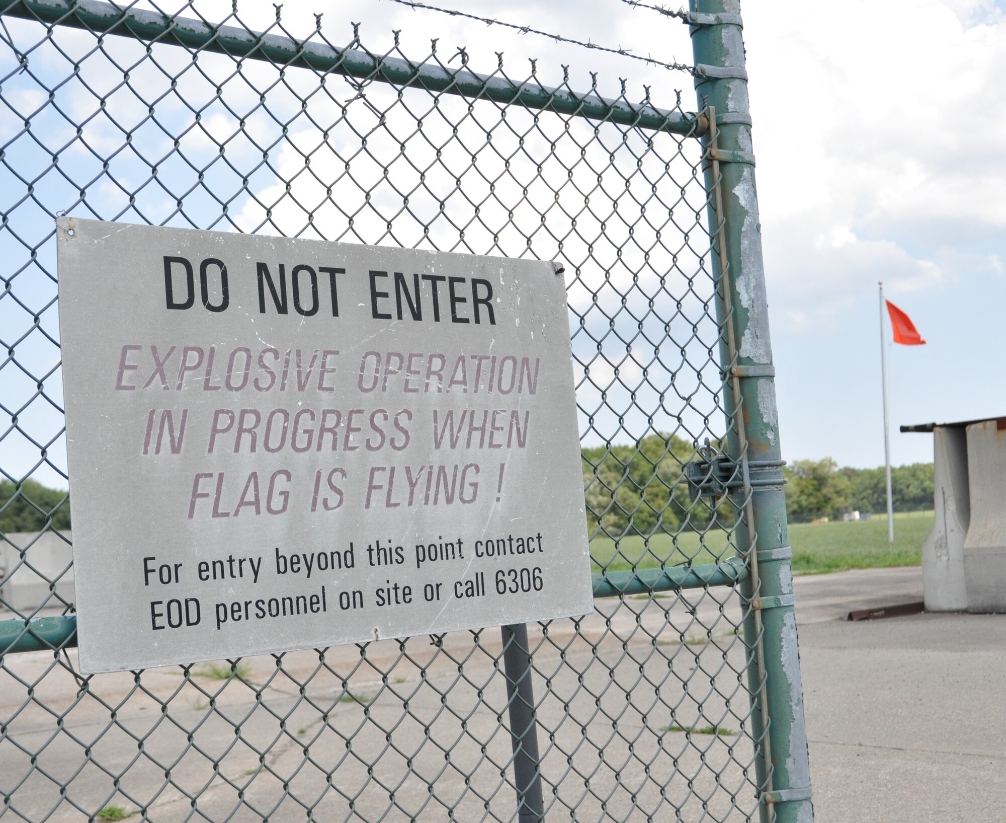 An orange flag flies Aug. 1, 2015, at the Explosive Ordnance Disposal proficiency range, Dover Air Force Base, Del., to signal to the base population when an EOD team is conducting live explosion training. The 512th EOD Flight simulated conventional weapons disposal by setting off three explosions using blocks of Composition C-4 and dynamite. (U.S. Air Force photo/Staff Sgt. Joe Yanik)   