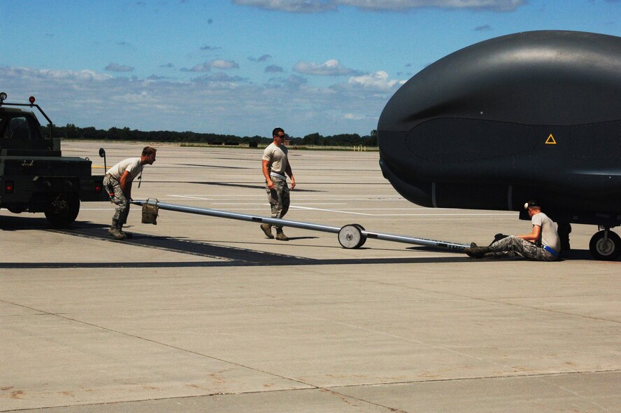 Airmen from the 69th Maintenance Squadron hook up an RQ-4 Global Hawk to the truck that will tow it back to the hangar July 28, 2015, on Grand Forks Air Force Base; N.D. The aircraft was being used as part of the Red Flag 15-3 exercise. Grand Forks AFB flew several flights as part of the exercise that involved many different agencies and bases. (U.S. Air Force photo by Airman 1st Class Ryan Sparks/released)
