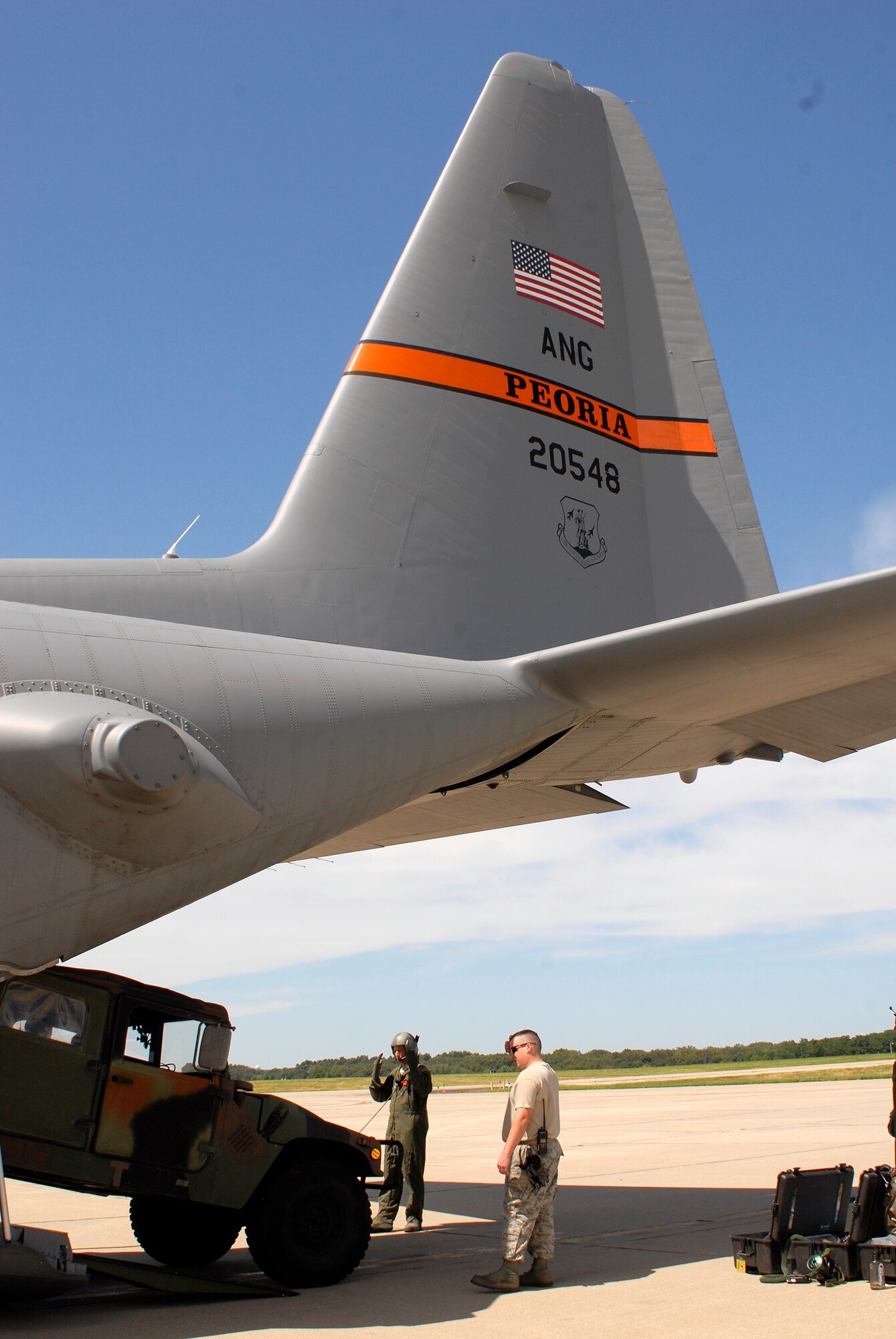 A loadmaster with the 169th Airlift Squadron, marshals a Humvee down a C-130 ramp during training at the 182nd Airlift Wing, Peoria, Ill., Aug. 1, 2015. The training was conducted to ensure that the loadmasters are always on mission and ready for real-world scenarios. (U.S. Air National Guard photo by Tech. Sgt. Dawn Rademaker/Released)