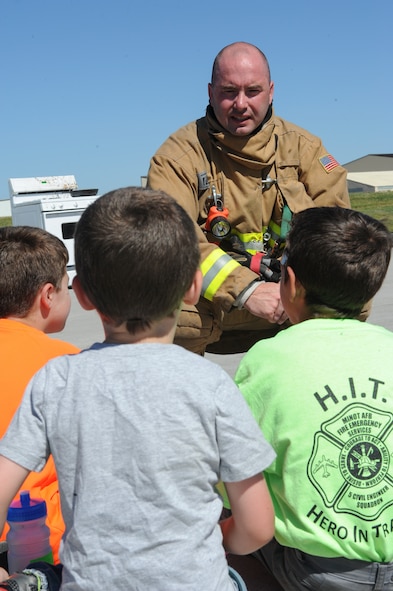 Staff Sgt. Sean Cantrell, 5th Civil Engineer Squadron fire station captain, answers children’s questions during the “Hero in Training” event at Minot Air Force Base, N.D., July 31, 2015. The fire department hosted the day-long event which featured displays from their group, the 5th Security Forces Squadron, 5th Medical group and a variety of other base agencies. (U.S. Air Force photo/Senior Airman Stephanie Morris)