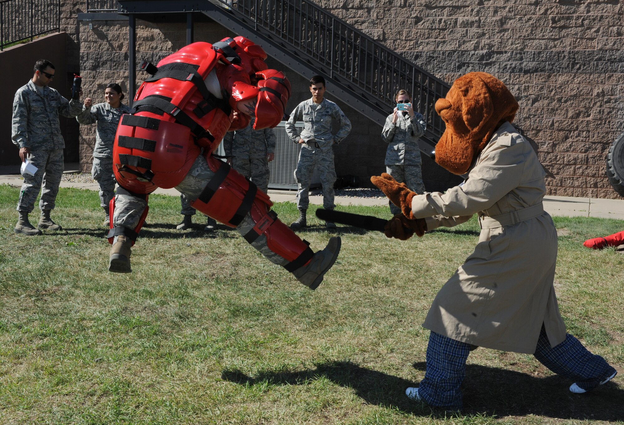 Scruff McGruff, the crime dog and Staff Sgt. Justin McCoy, 5th Security Forces Squadron armory assistant NCO in charge, demonstrate baton training during the “Hero in Training” event at Minot Air Force Base, N.D., July 31, 2015. The baton training demonstration also had an interactive portion during which children could test their skills with McCoy. (U.S. Air Force photo/Senior Airman Stephanie Morris)