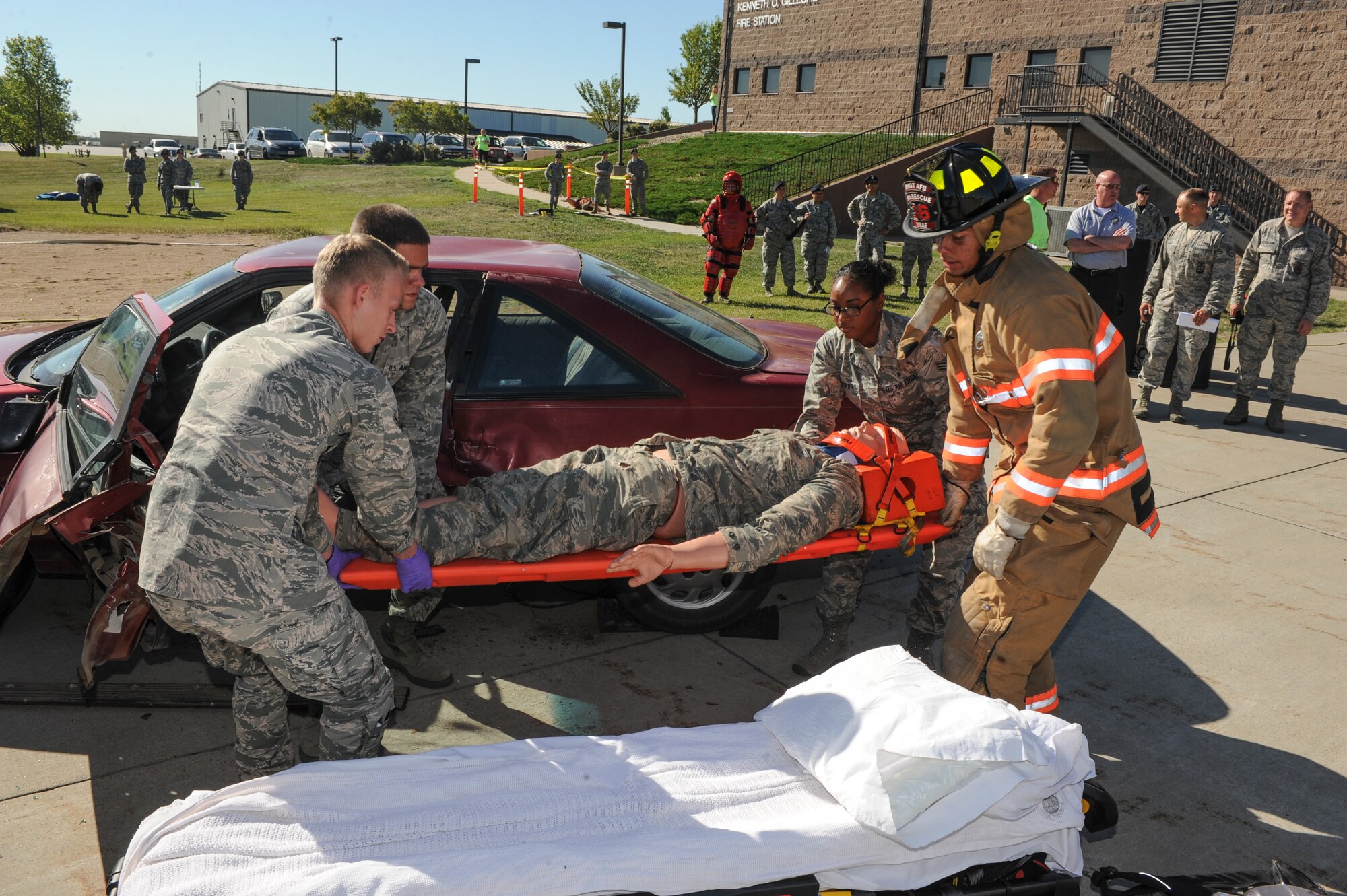Airmen from the 5th Medical Group and base fire department remove a dummy from a simulated car accident during the “Hero in Training” event at Minot Air Force Base, N.D., July 31, 2015. During the demonstration, fire fighters showed children and their families tools, such as the Jaws of Life, and procedures they use to rescue car crash victims. (U.S. Air Force photo/Senior Airman Stephanie Morris)