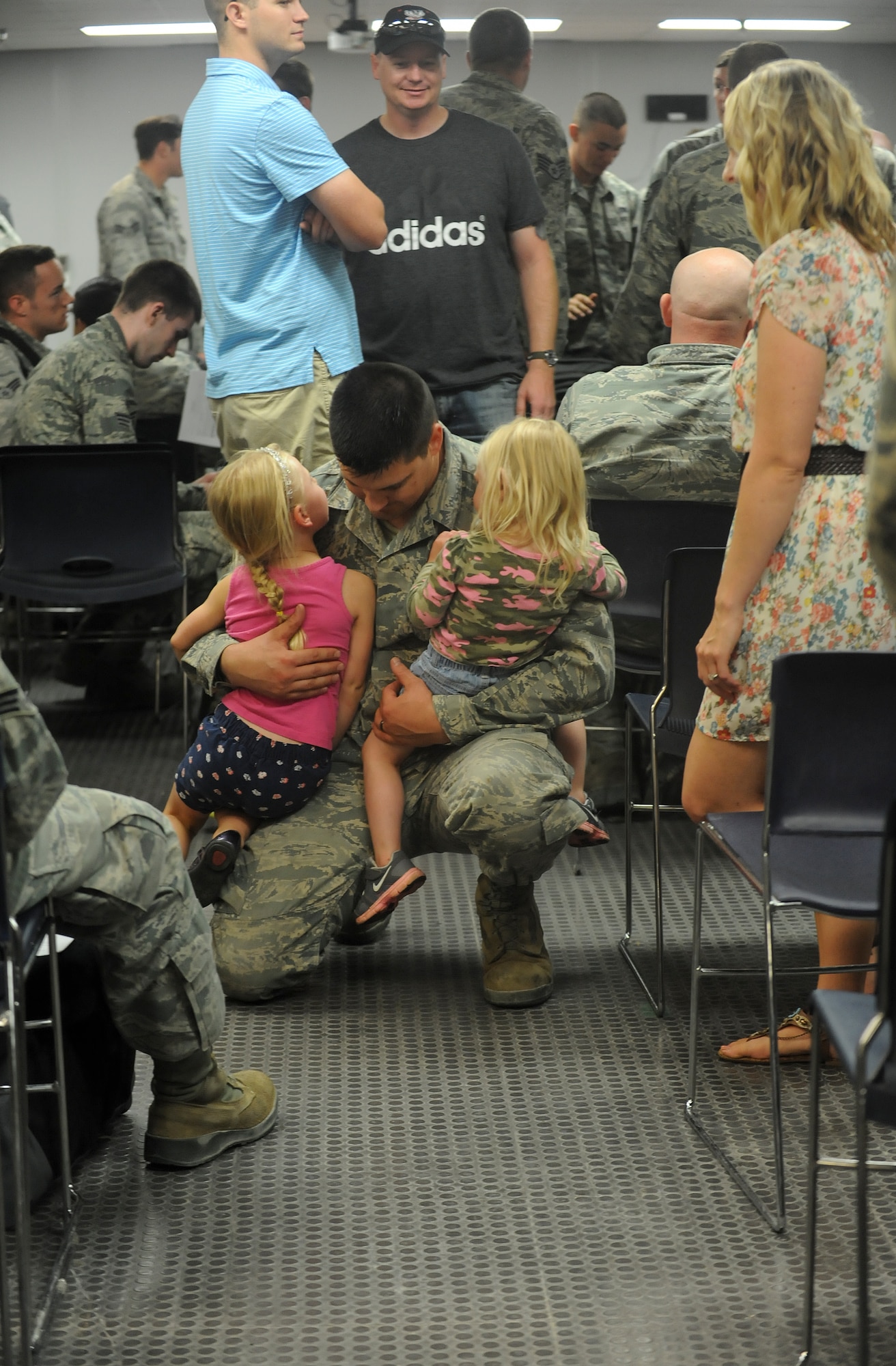 Staff Sgt. David Wagner, 5th Maintenance Squadron metals technologist, holds his daughters Aleana and Layla at Minot Air Force Base, N.D., Aug. 1, 2015. Wagner returned from spending approximately three weeks at Nellis Air Force Base, Nev., where he participated in Red Flag 15-3 training. (U.S. Air Force photo/Senior Airman Stephanie Morris)