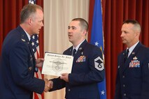 Col. Michael A. Vogel, 66th Air Base Group commander, congratulates Senior Master Sgt. Michael R. Standring, 66th Medical Squadron flight chief, on his promotion to E-8 during the August enlisted promotion ceremony at the Minuteman Commons July 31, as Hanscom Command Chief Master Sgt. Craig A. Poling looks on. Standring and four others were recognized during the monthly enlisted promotion ceremony. (U.S. Air Force photo by Jerry Saslav)