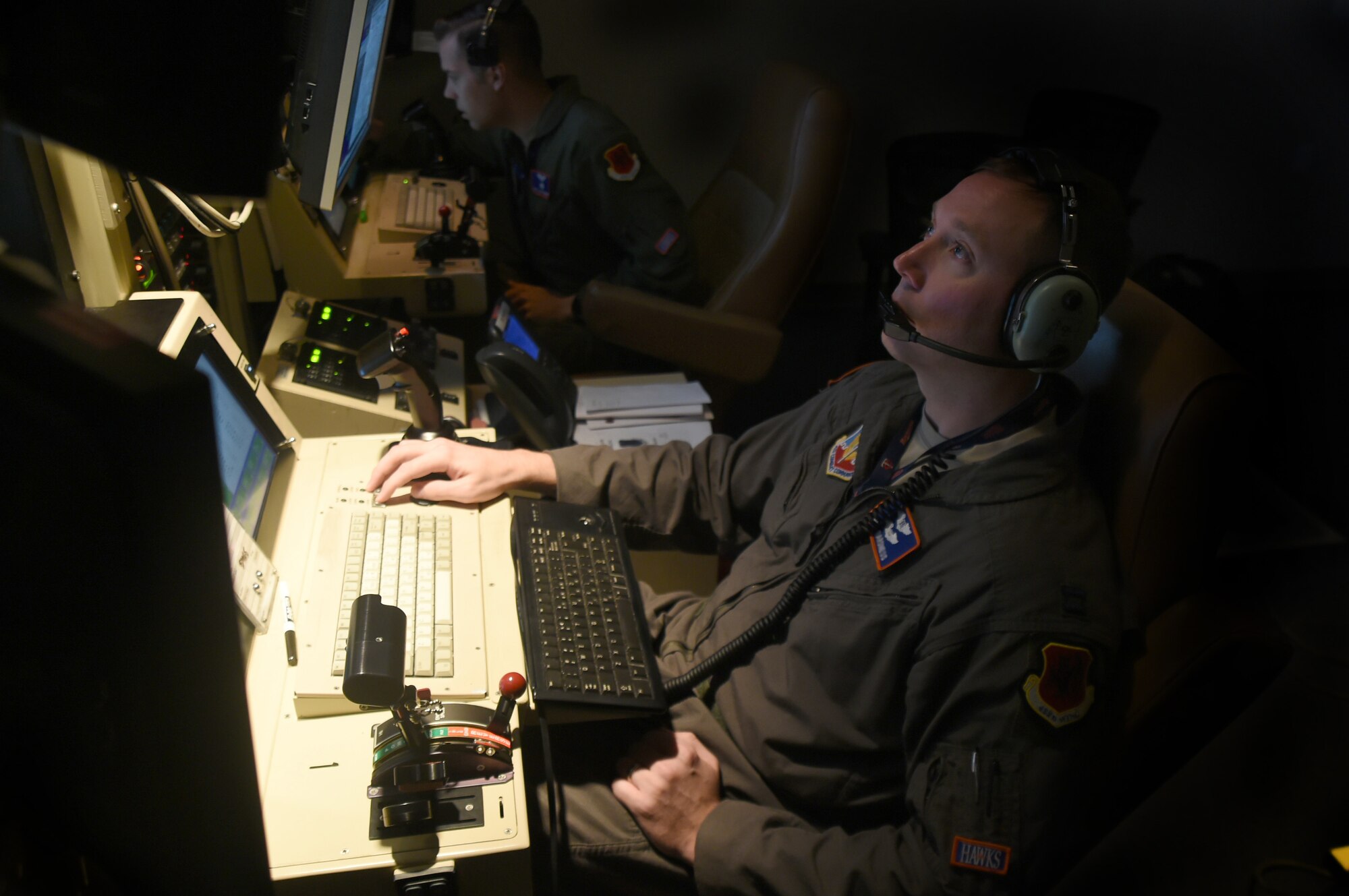 (Left) Staff Sgt. Lloyd, 18th Reconnaissance Squadron MQ-1 Predator sensor operator and Capt. Benjamin, 18th RS MQ-1 Predator pilot (right), fly a remotely piloted aircraft training sortie in support of Red Flag 15-3 at Creech Air Force Base, Nevada on July 23, 2015. The goal of participating in Red Flag exercises is to fully integrate RPAs into large force exercises (LFEs), to include educating other major weapon systems (MWS) communities on the RPA capabilities to enable mission essential support for war planners. (U.S. Air Force photo by Tech. Sgt. Nadine Barclay)