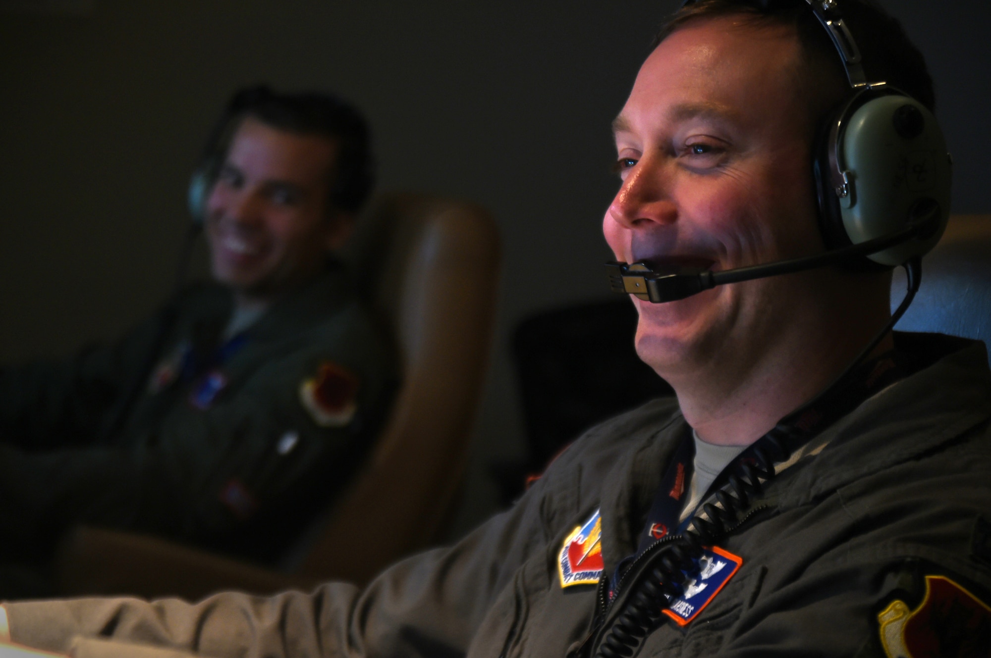 (Left) Staff Sgt. Lloyd, 18th Reconnaissance Squadron MQ-1 Predator sensor operator and Capt. Benjamin, 18th RS MQ-1 Predator pilot (right), laugh while flying a remotely piloted aircraft training sortie in support of Red Flag 15-3 at Creech Air Force Base, Nevada on July 23, 2015. The goal of participating in Red Flag exercises is to fully integrate RPAs into large force exercises (LFEs), to include educating other major weapon systems (MWS) communities on the RPA capabilities to enable mission essential support for war planners. (U.S. Air Force photo by Tech. Sgt. Nadine Barclay)