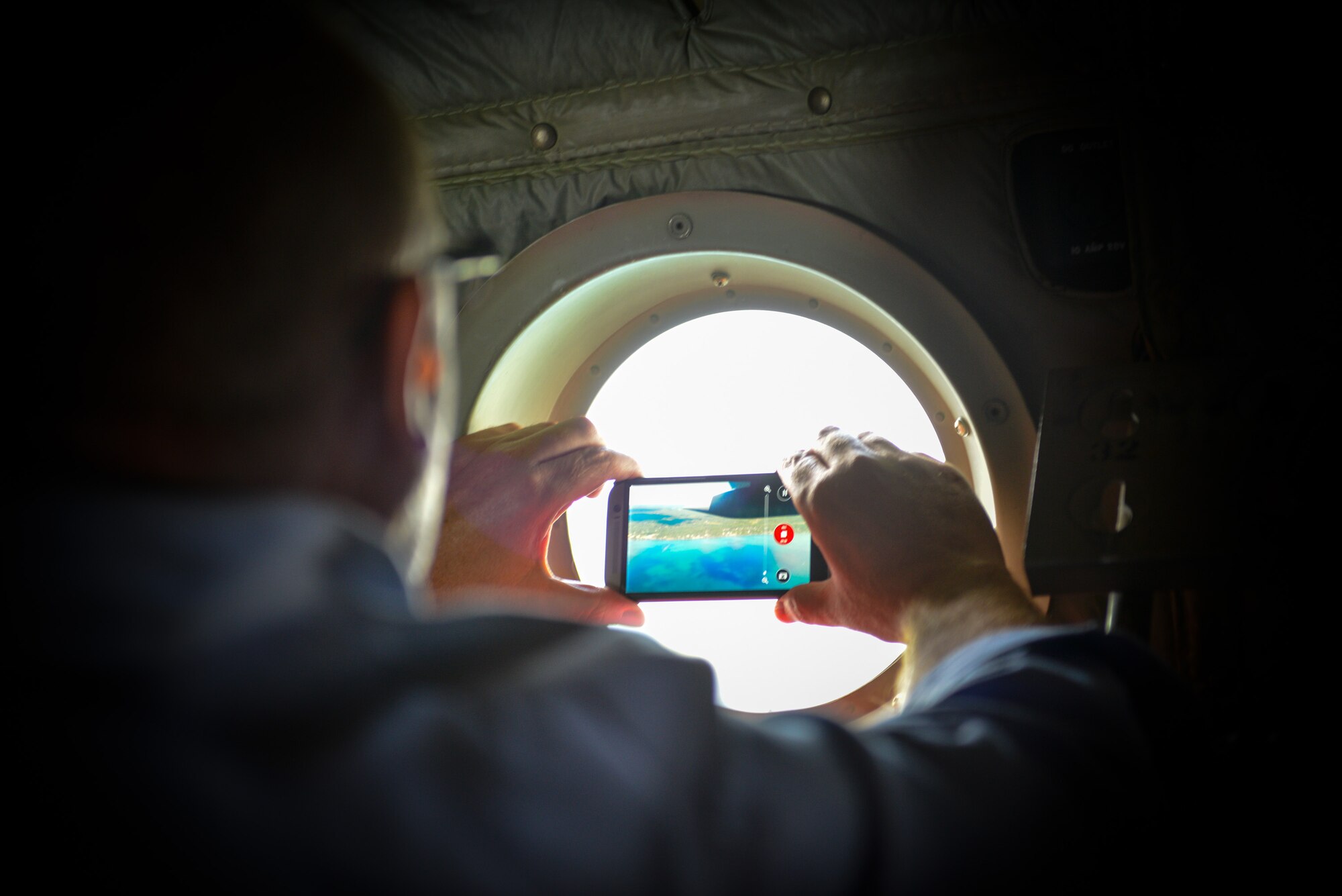 Michael Witzel, the employer of Master Sgt. Shawn Clark of the 934th Civil Engineering Squadron, records his view from the window portal during an incentive flight aboard a C-130 aircraft. Employers were invited to the August training assembly weekend for the annual Employer's Day event at the Minneapolis-St. Paul Air Reserve Station, Minn. (U.S. Air Force photo by Staff Sgt. Corban Lundborg/Released)