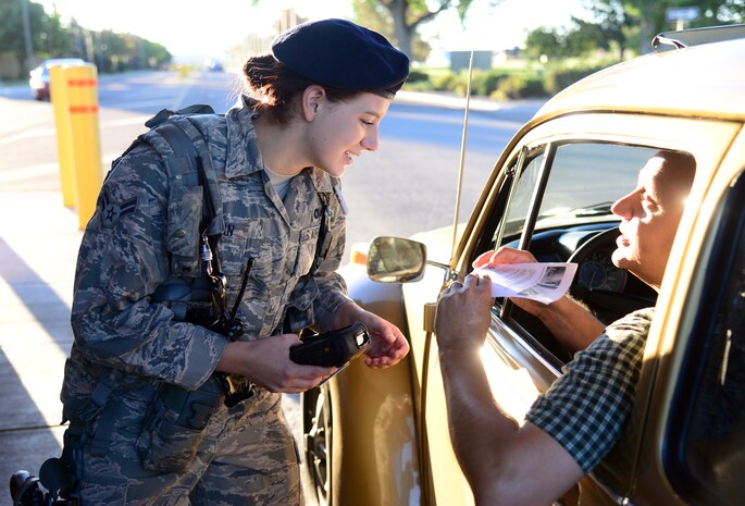 Airman 1st Class Heidi Curfman, 341st Security Forces Squadron defender, checks an ID at the front gate July 31, 2015, at Malmstrom Air Force Base, Mont. Curfman conducts a 100 percent vehicle occupancy ID check at the gate before allowing entry onto the base. (U.S. Air Force photo/Airman 1st Class Magen M. Reeves)