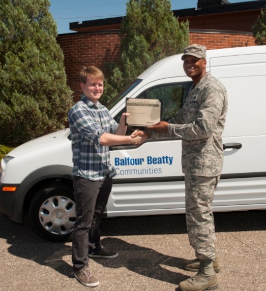 Col. Roy Collins, 5th Mission Support Group commander, gives scholarship recipient, Troy Huber, his Balfour Beatty Communities Foundation Academic Scholarship certificate at Minot Air Force Base, N.D., July 24, 2015. BBC awarded 52 academic scholarships for the 2015-2016 year. (U.S. Air Force photo/Airman 1st Class Christian Sullivan)