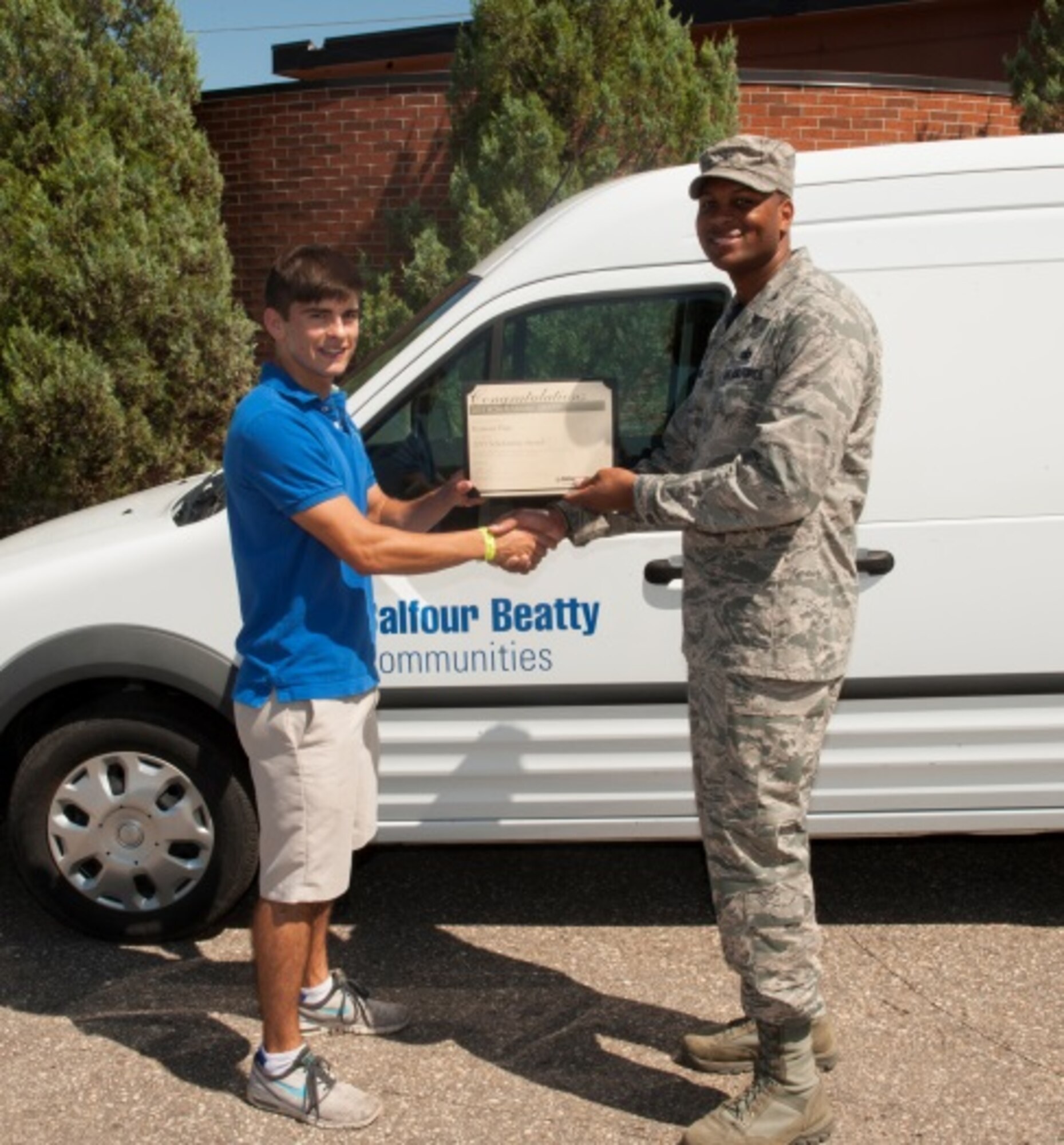 Col. Roy Collins, 5th Mission Support Group commander, gives scholarship recipient, Romone Frias, his Balfour Beatty Communities Foundation Academic Scholarship certificate at Minot Air Force Base, N.D., July 24, 2015. BBC awarded 52 academic scholarships for the 2015-2016 year. (U.S. Air Force photo/Airman 1st Class Christian Sullivan)