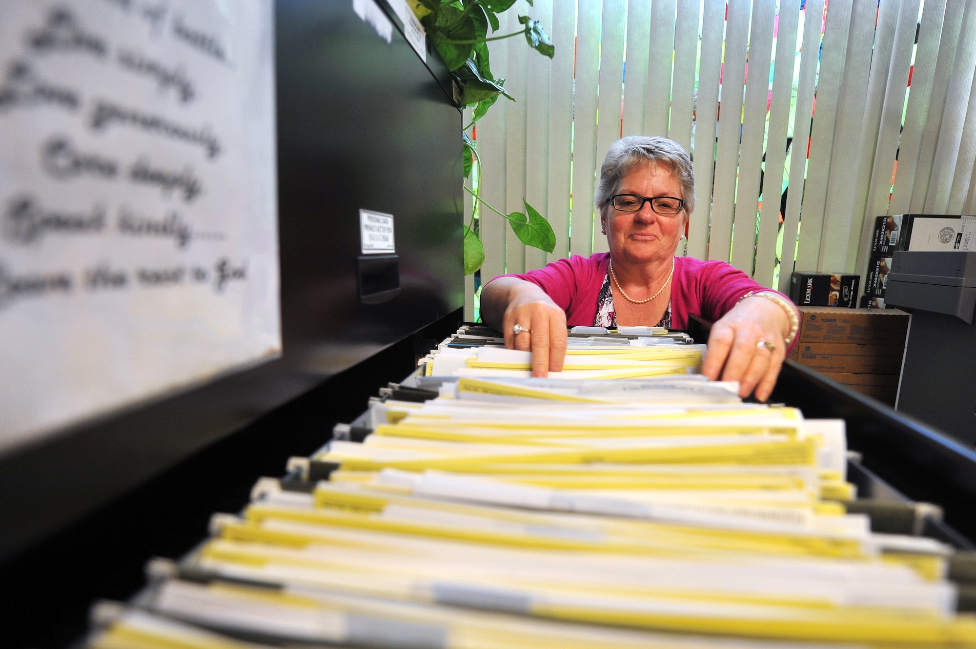 Pamela Clark, 55th Wing Judge Advocate tax representative, looks through her files July 31 at the tax center housed out of Offutt Air Force Base, Nebraska, legal office. Clark has been helping Team Offutt members with their taxes for more than a decade. (U.S. Air Force photo by Josh Plueger)