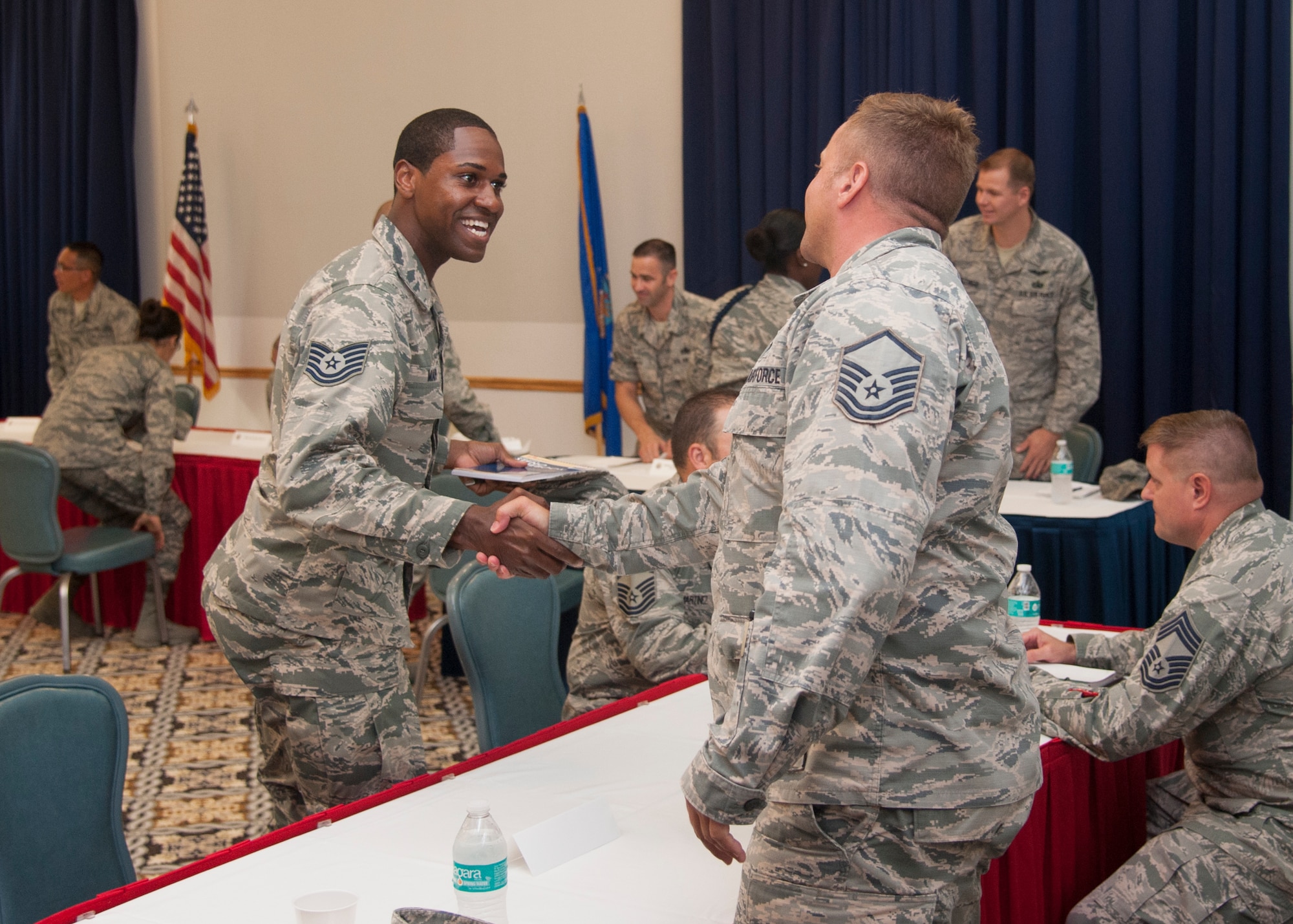 Tech Sgt. Demetrius Mapp, 373 Training Squadron instructor, shakes hands with Master Sgt. John Willard, 436th Airlift Wing Safety superintendent, after a mentoring session during the Top III’s Speed Mentoring event, July 29, 2015, at The Landings Club on Dover Air Force Base, Del. Willard spoke with Mapp about various career topics. (U.S. Air Force photo/Senior Airman Jared Duhon) 
