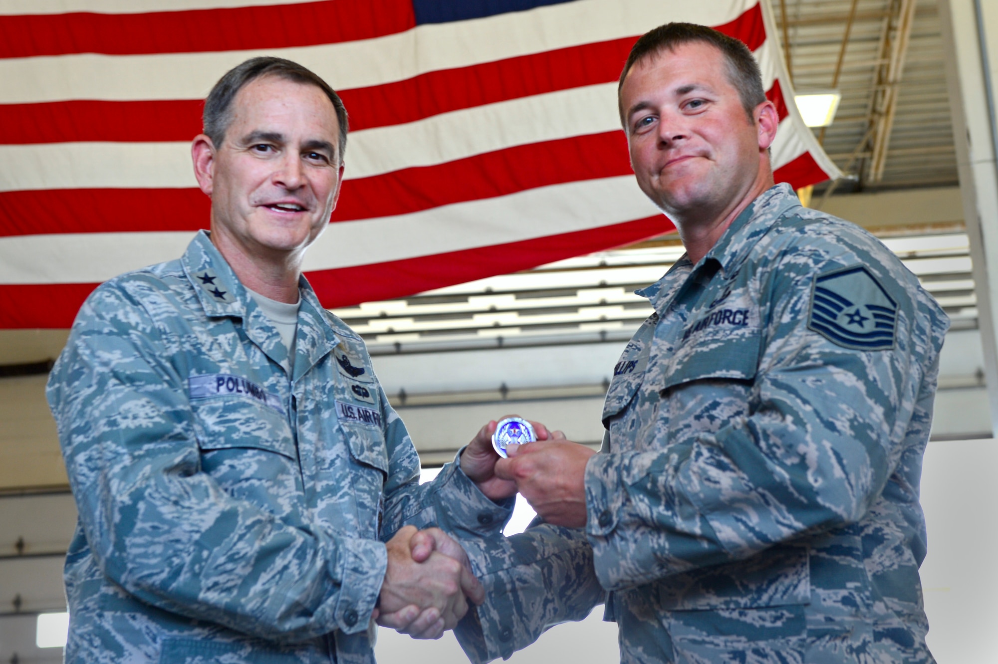 U.S. Air Force Maj. Gen. H. D. Polumbo Jr., Ninth Air Force commander, gives a Ninth Air Force commander’s coin to Master Sgt. Jeremy Phillips, 20th Civil Engineer Squadron explosive ordinance disposal technician, at Shaw Air Force Base, S.C., July 28, 2015. Polumbo thanked Phillips for his leadership role during the response to a mid-air collision involving a 20th Fighter Wing F-16CM Fighting Falcon. (U.S. Air Force photo by Senior Airman Jensen Stidham/Released)