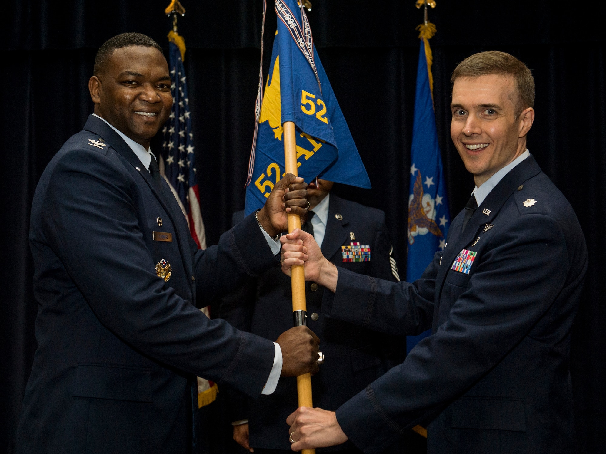 U.S. Air Force Col. Alfred Flowers, 52nd Medical Group commander, left, hands a ceremonial guidon to U.S. Air Force Lt. Col.  David Andrus, the incoming 52nd Aerospace Medicine Squadron commander, during the 52nd AMDS change of command ceremony at Spangdahlem Air Base, Germany, Aug. 3, 2015. Andrus assumed command from former commander, U.S. Air Force Lt. Col. Daniel Murray. (U.S. Air Force photo by Senior Airman Rusty Frank/Released)
