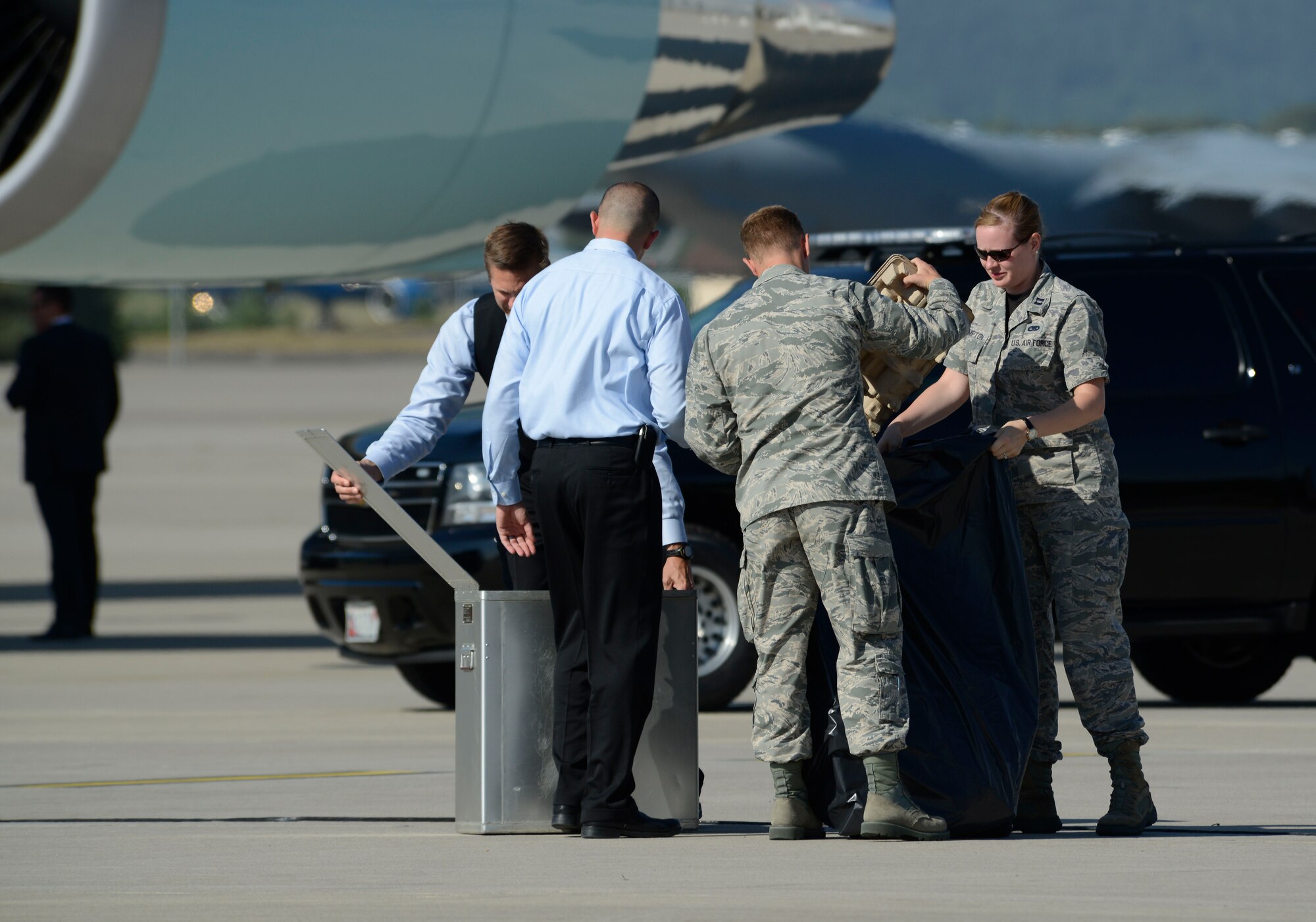 Capt. Teresa Crampton, 721st Aerial Port Squadron air freight flight commander, and 2nd Lt. Denver Barrows, 721st APS ramp services officer in charge, gather trash from Air Force One flight attendants July 24, 2015, at Ramstein Air Base, Germany. President Obama was traveling to Africa and stopped at Ramstein to refuel. (U.S. Air Force photo/Airman 1st Class Tryphena Mayhugh)