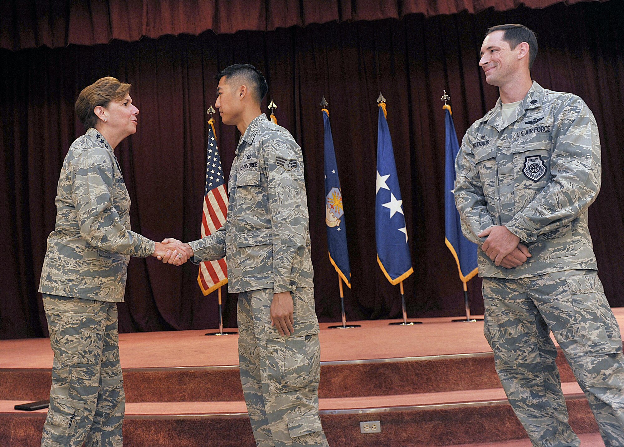 U.S. Air Force Gen. Lori J. Robinson, Pacific Air Forces commander, coins U.S. Air Force Senior Airman Jesse Kow, 18th Operations Support Squadron air traffic controller, at the Kadena Officer’s Club on Kadena Air Base, Japan, Aug. 3, 2015. During her two-day visit, the general addressed several issues that are important to her, including Airmen taking care of Airmen and the strategic shift to the Pacific. She also communicated her expectations with Kadena leaders. (U.S. Air Force photo by Naoto Anazawa/Released)