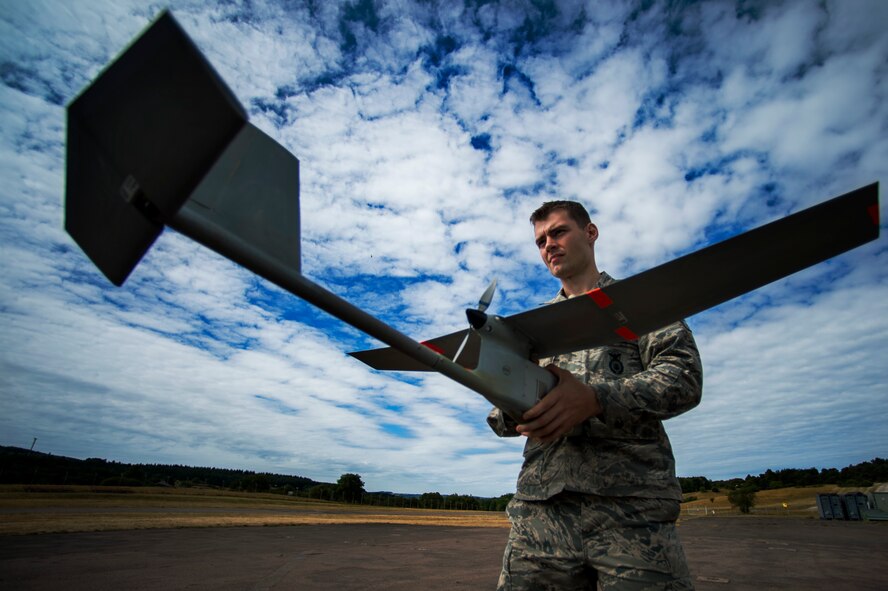 U.S. Air Force Senior Airman Tazz Berry, a 52nd Security Forces Squadron patrolman, holds a Raven B small unmanned aerial system with digital data link for pre-flight checks during a SUAS proficiency and currency training at the airfield on U.S. Army Garrison Baumholder, Germany, July 23, 2015. The operators must retain knowledge on how to pilot the SUAS and perform checks before and after each flight. (U.S. Air Force photo by Airman 1st Class Timothy Kim/Released)